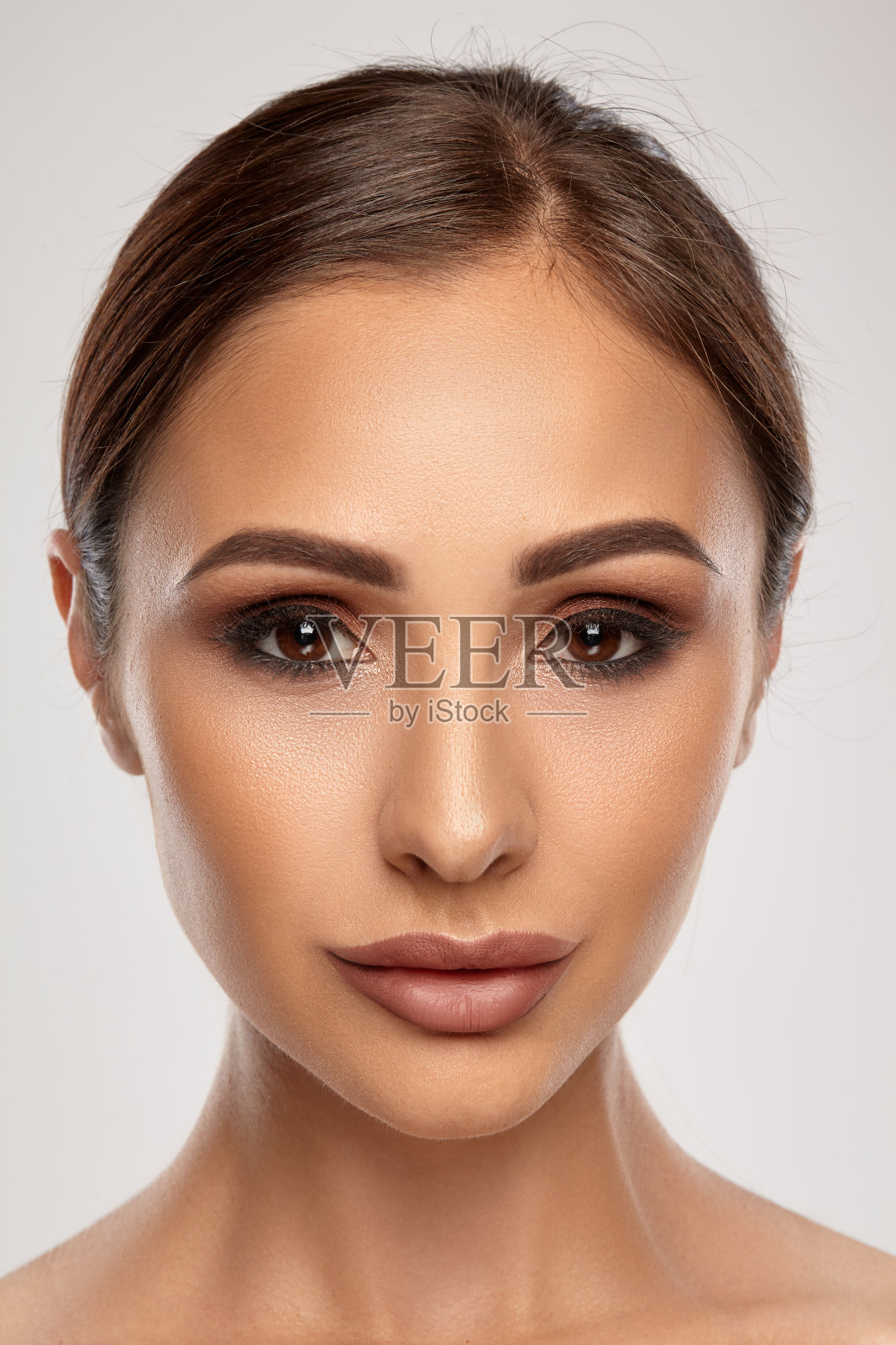 近距离肖像的一个黑发模特女孩与专业的晚妆和丰满的嘴唇，摆出灰色的背景照片摄影图片