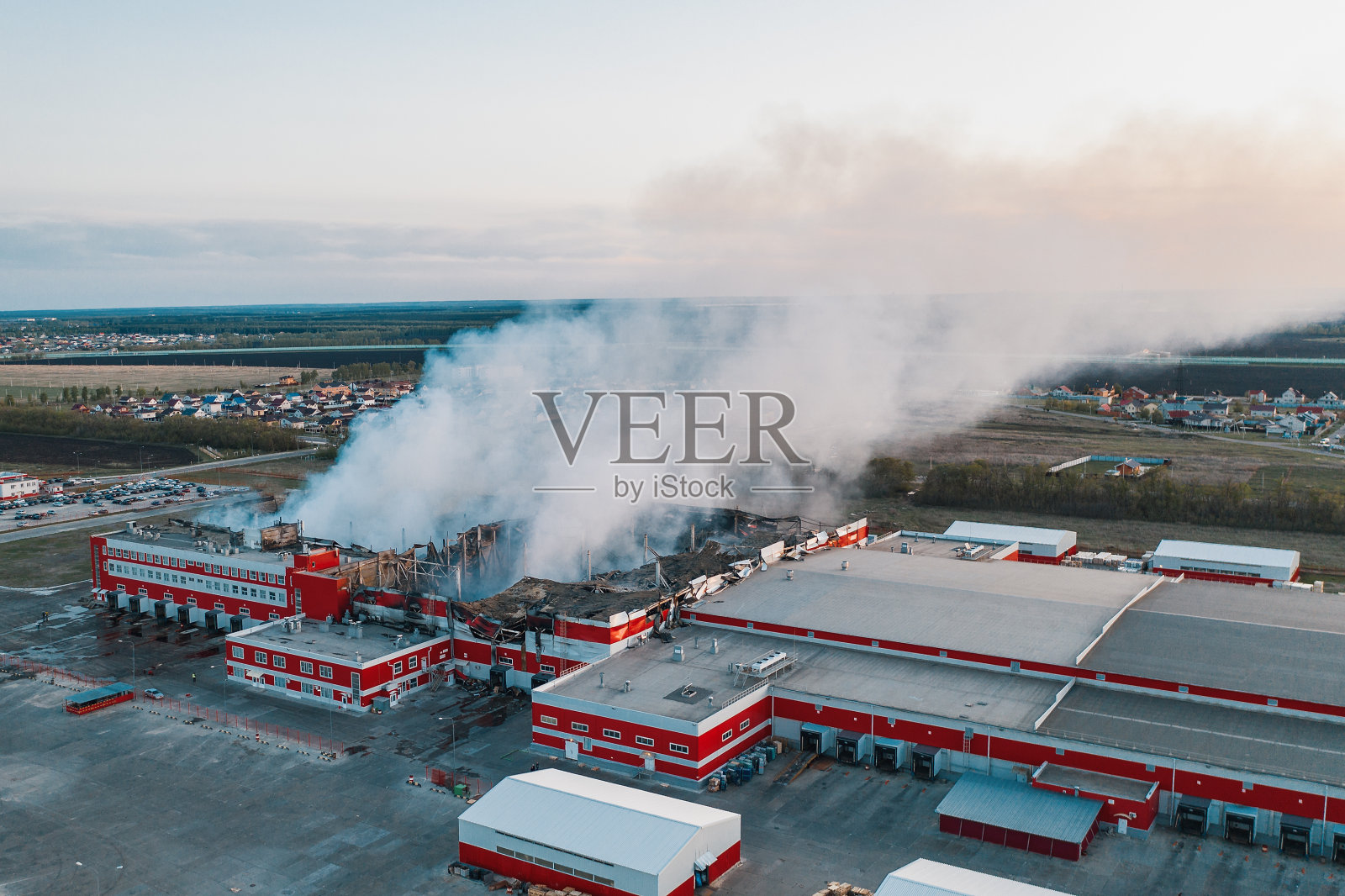 航拍燃烧的工业建筑和巨大的烟雾从燃烧的屋顶，火灾无人机照片照片摄影图片