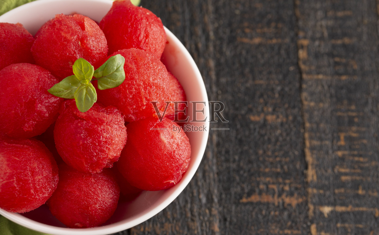 深色木质表面上的多汁西瓜球照片摄影图片