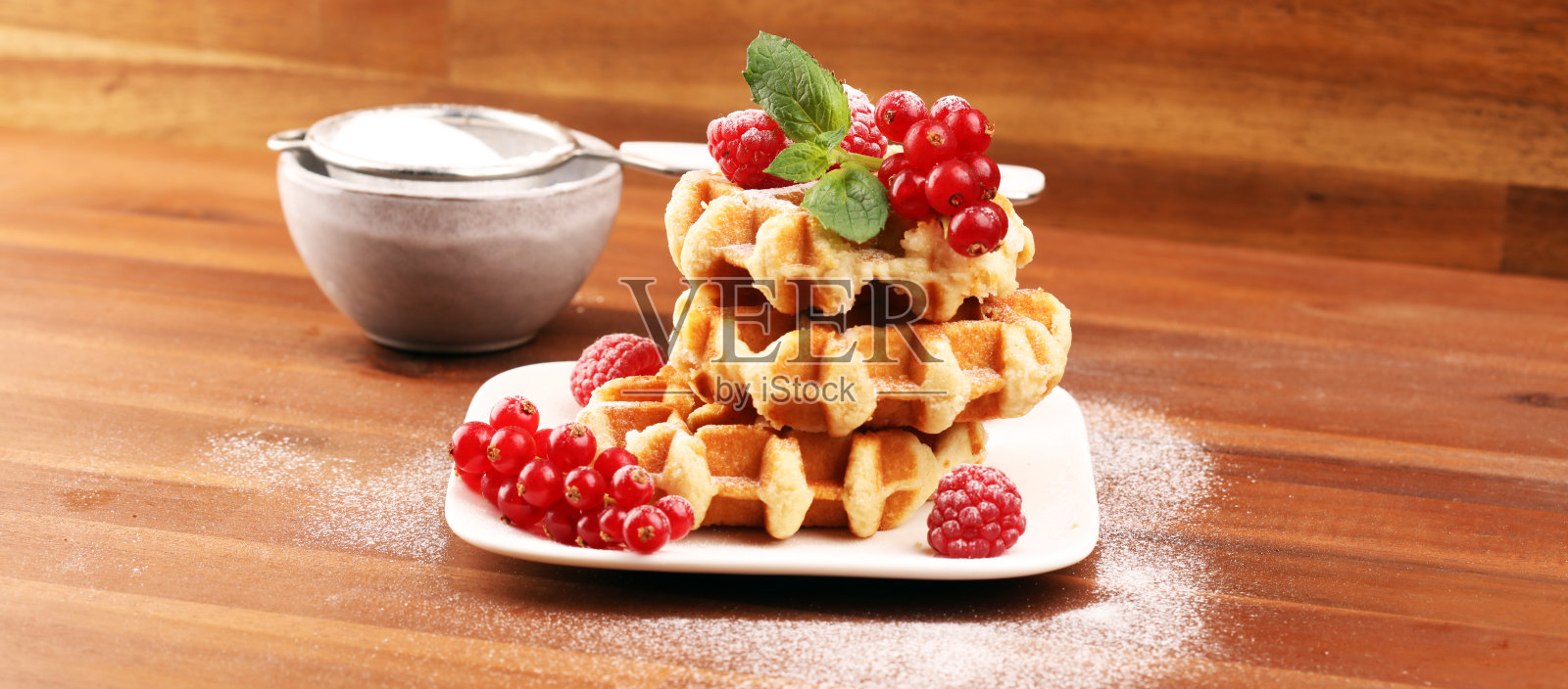 传统的比利时华夫饼配上新鲜的薄荷，糖和树莓照片摄影图片