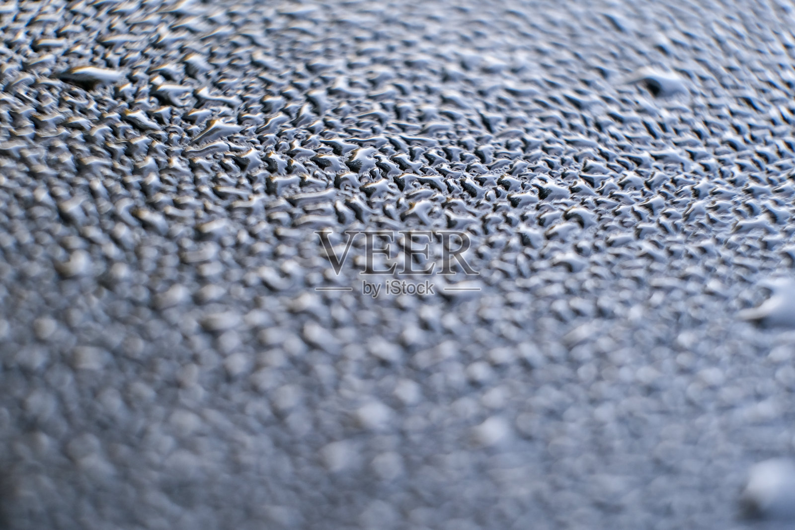 一滴水滴在汽车玻璃上。抽象的模式照片摄影图片