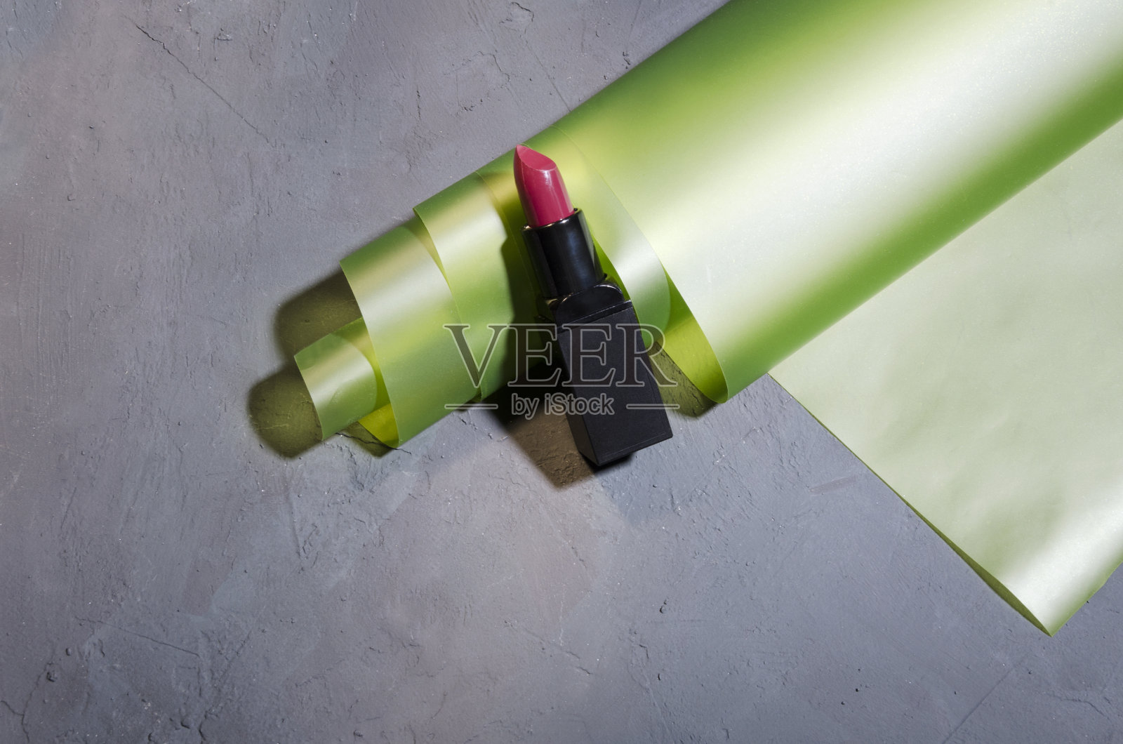 黑色管中的红色唇膏，黑色复古表面的包装纸。设计空间照片摄影图片