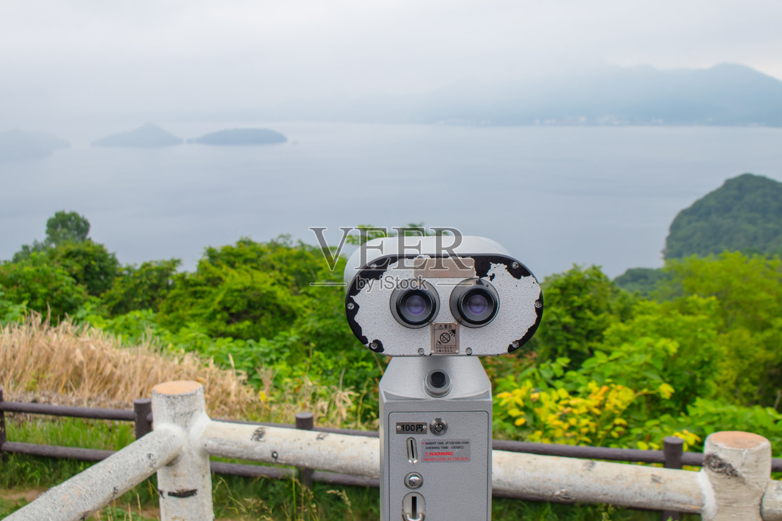 在日本北海道寻找热带景观的游客可以使用双筒望远镜或望远镜俯瞰洞屋湖。照片摄影图片