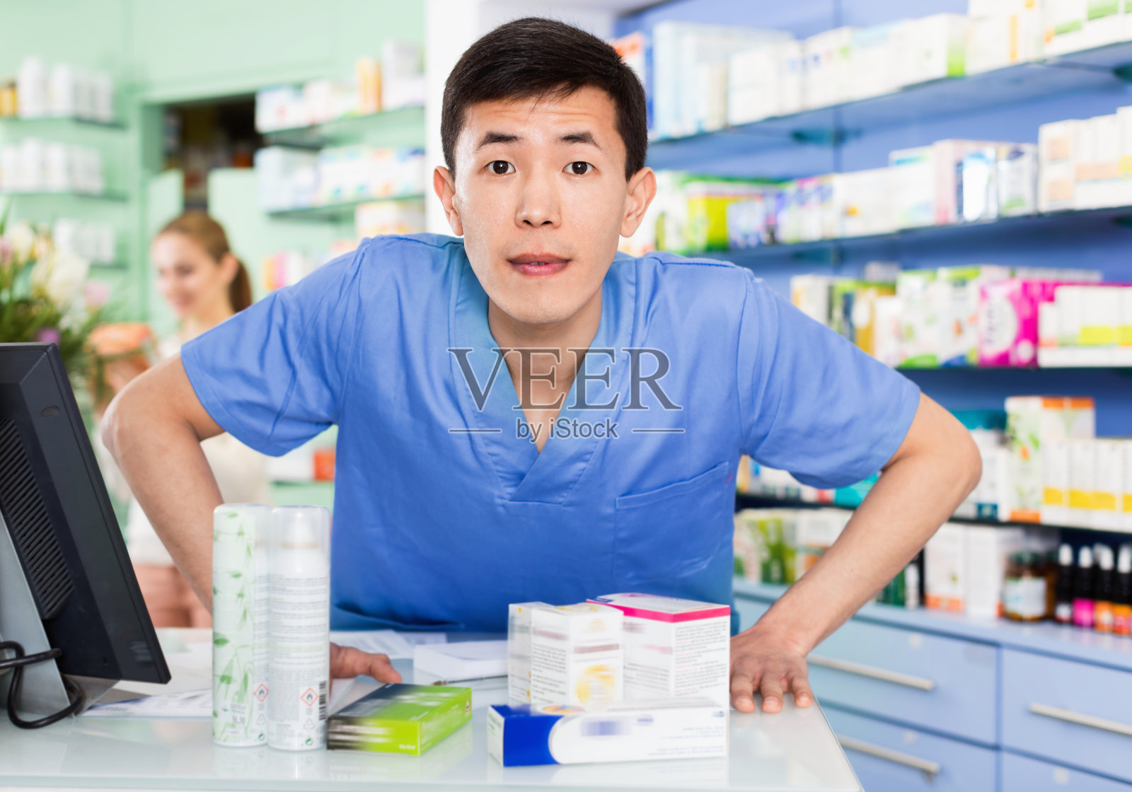 中国男子药剂师的肖像是站在他的工作地点附近的现金箱在药剂师。照片摄影图片