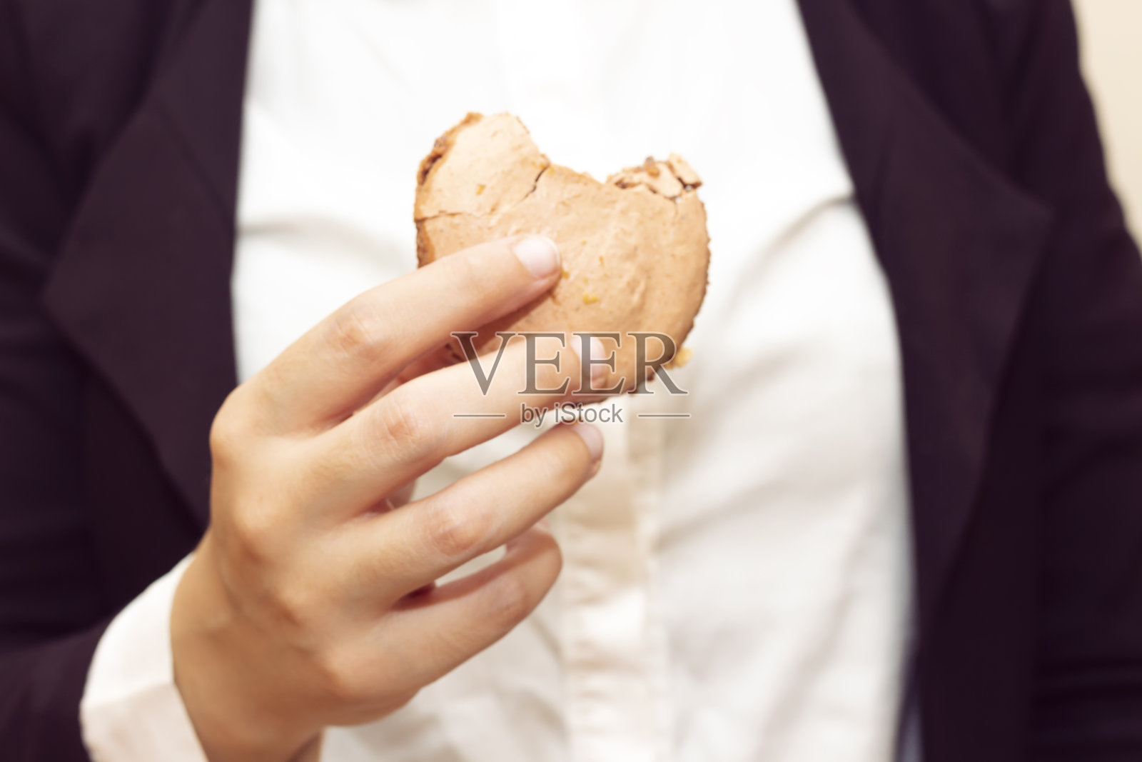特写女商人吃美味的马卡龙照片摄影图片