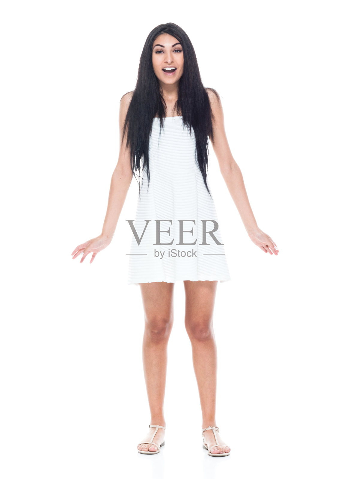 全长/正面视图18-19岁美丽的黑发/长头发拉丁美洲和西班牙裔种族的女性/年轻的妇女十几岁的女孩站在白色背景穿着裙子谁是惊讶/震惊照片摄影图片