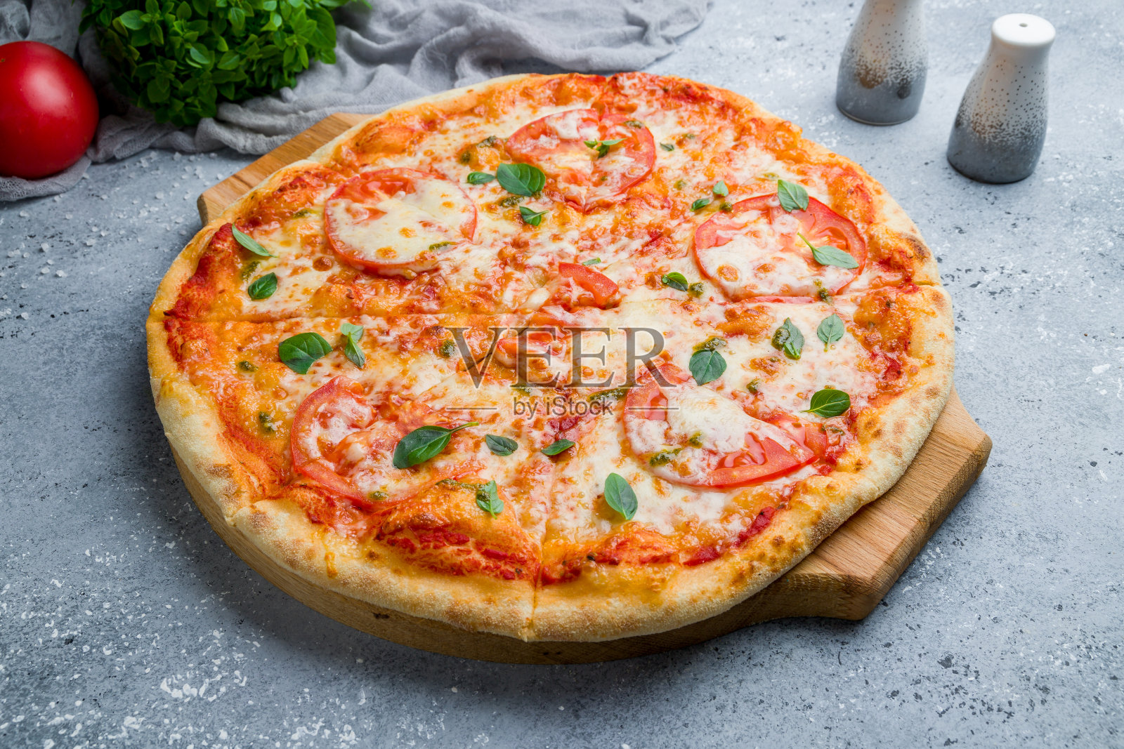 意大利玛格丽塔披萨配西红柿和罗勒在漂亮的灰色桌子上照片摄影图片