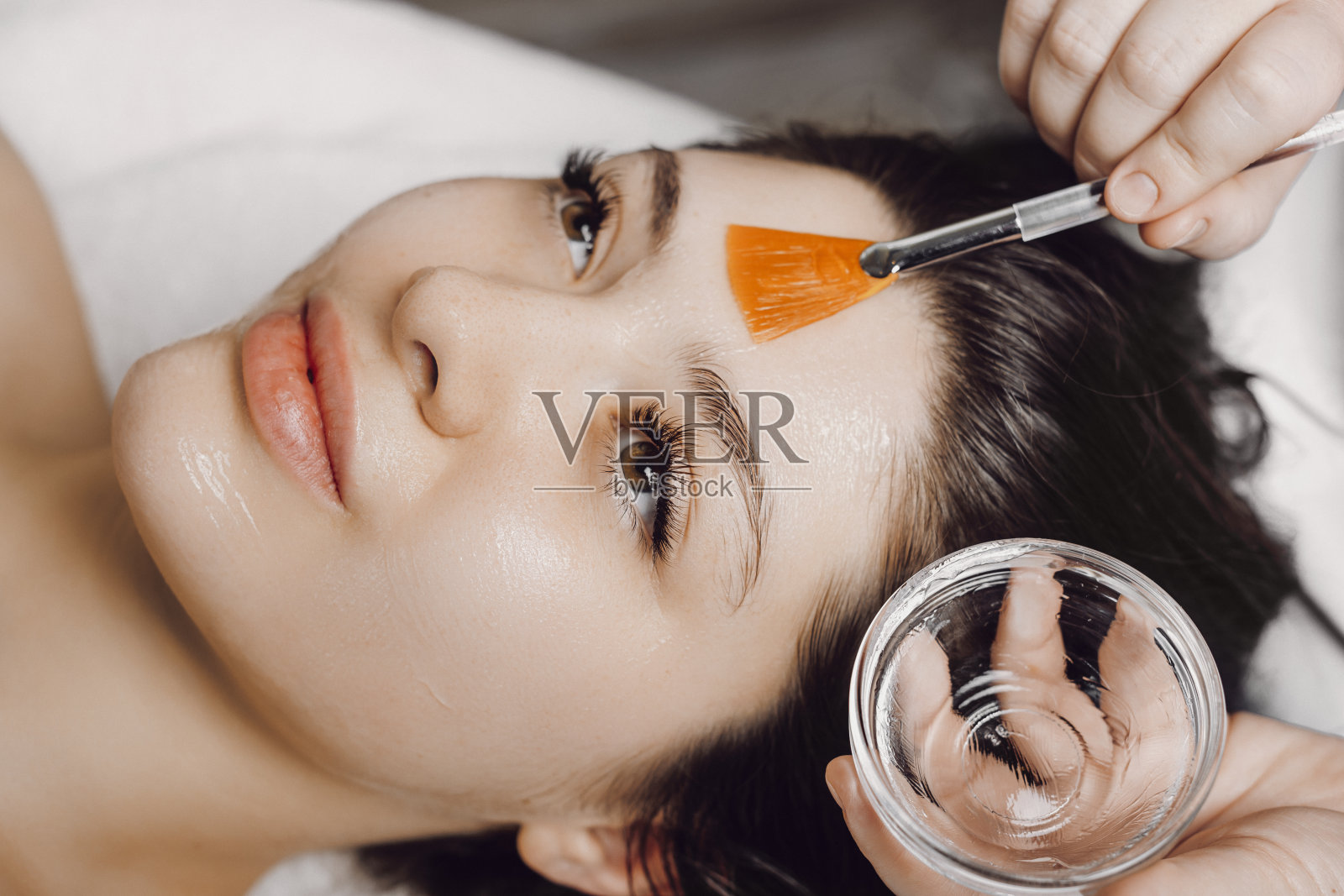 一个迷人的白种女人的特写有抗衰老面膜在水疗中心。照片摄影图片