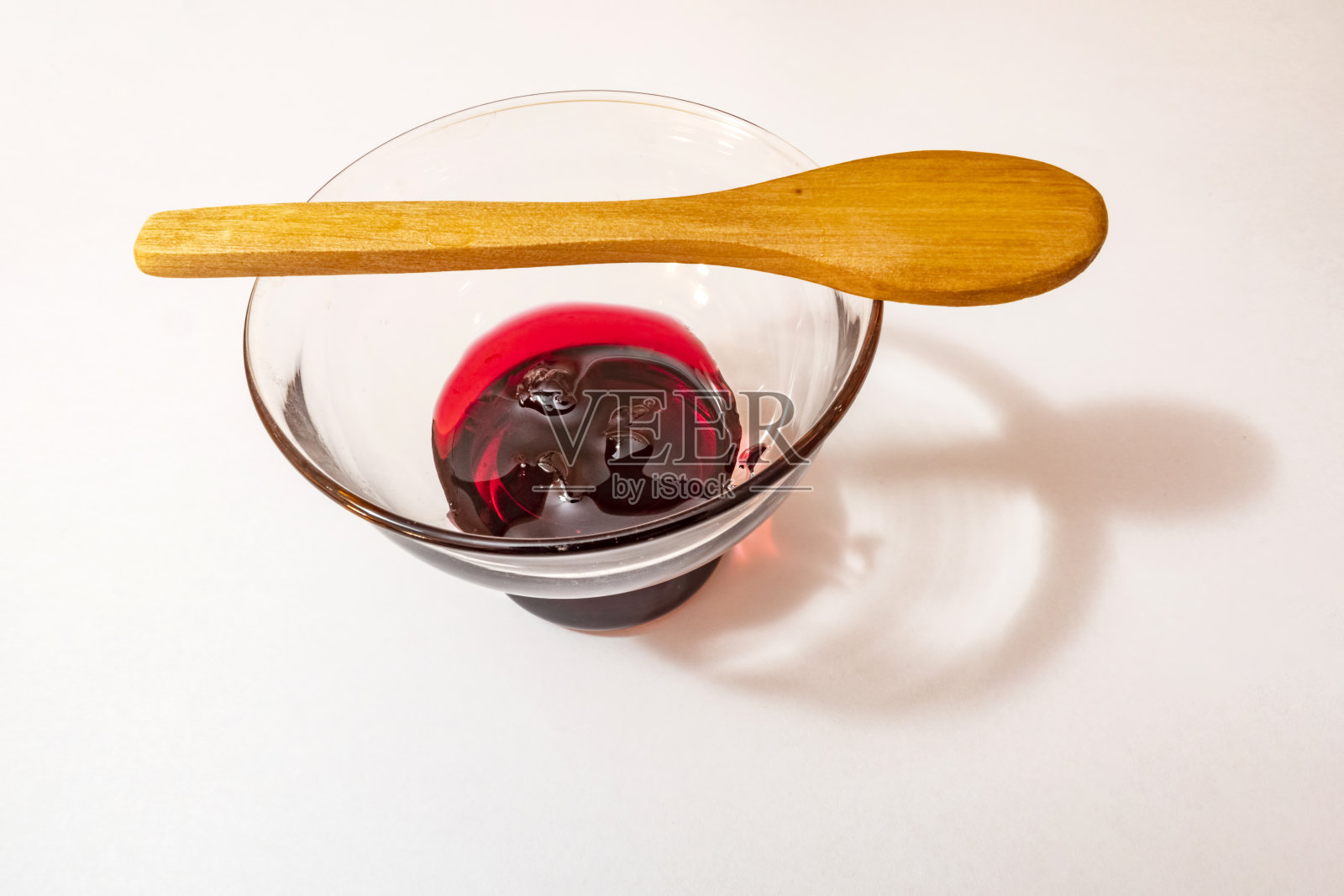 玻璃碗里的樱桃果酱和小木勺照片摄影图片