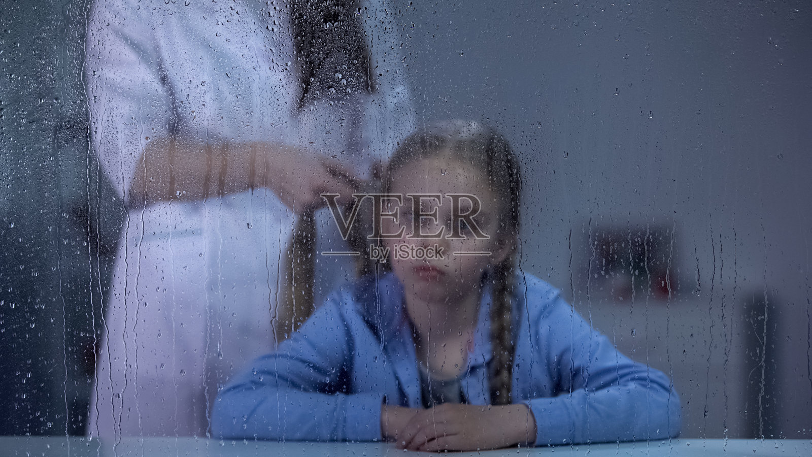 护士在雨窗后编女孩的头发，护理在医院，医疗诊所照片摄影图片