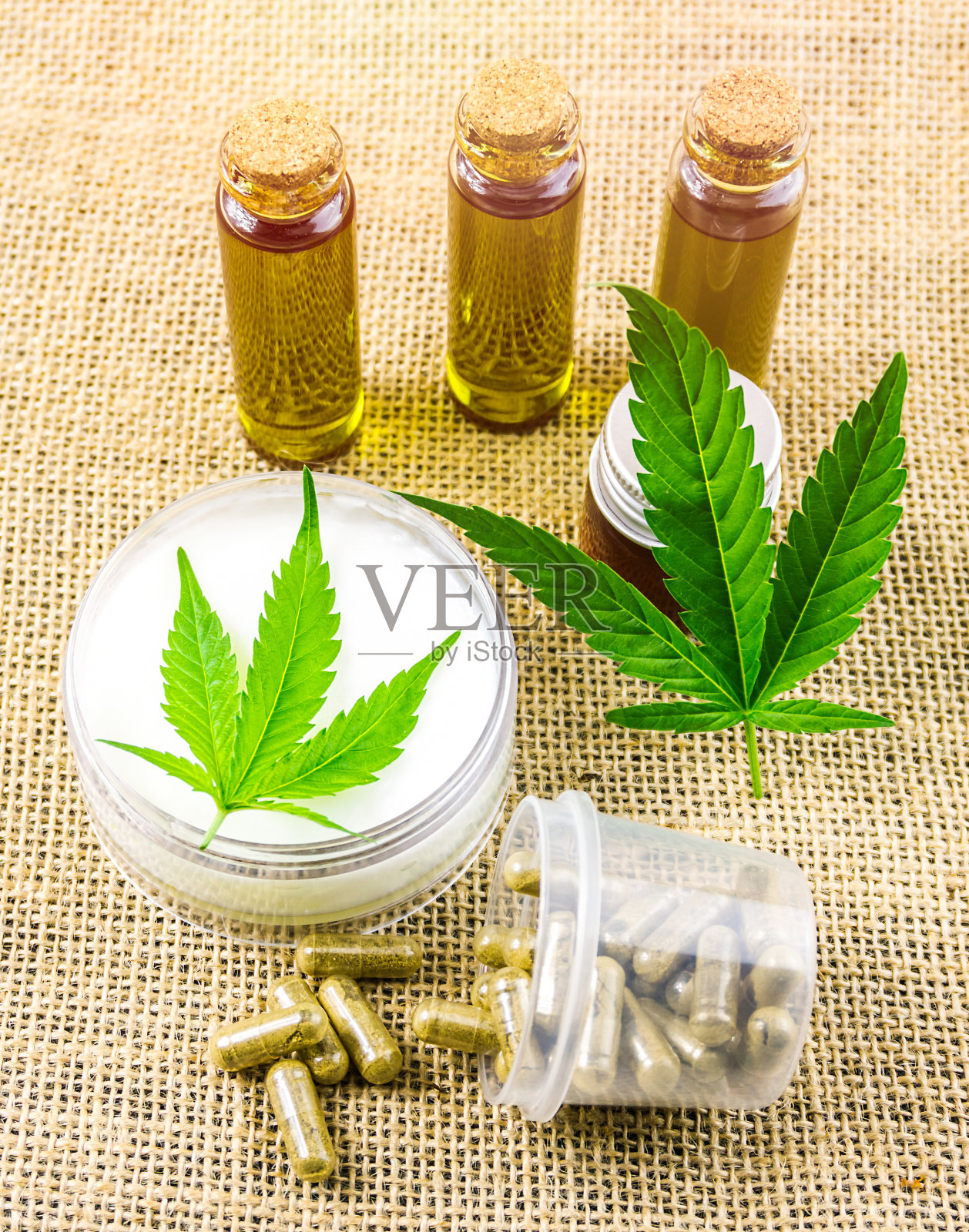 大麻纤维布上的全光谱CBD和四氢大麻酚油、药丸和CBD乳液照片摄影图片