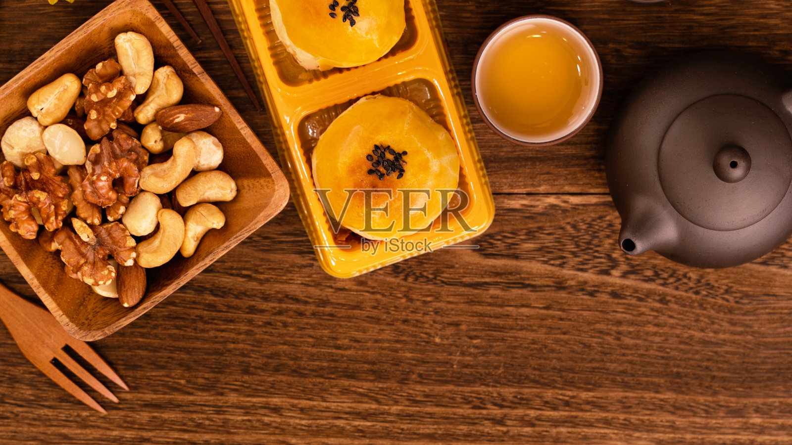 月饼配茶几放在深色木桌上，假日概念的中秋节传统食品布局设计。照片摄影图片