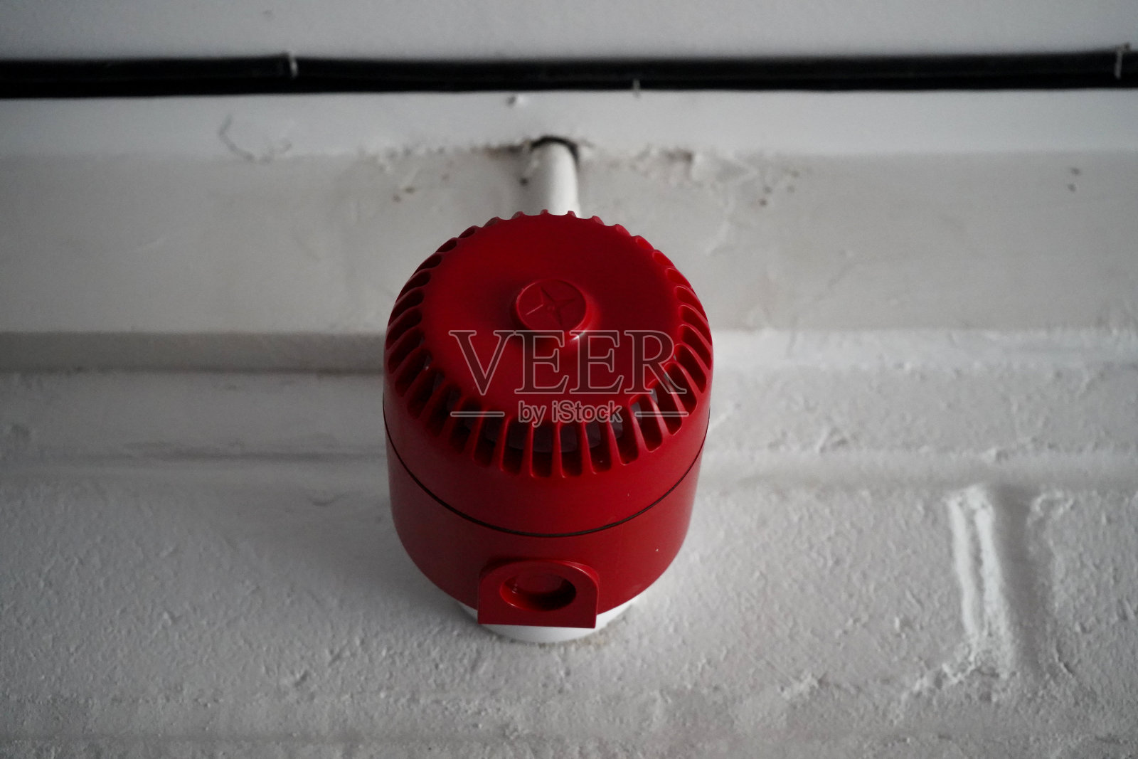 白色墙壁上的红色火警警报器照片摄影图片