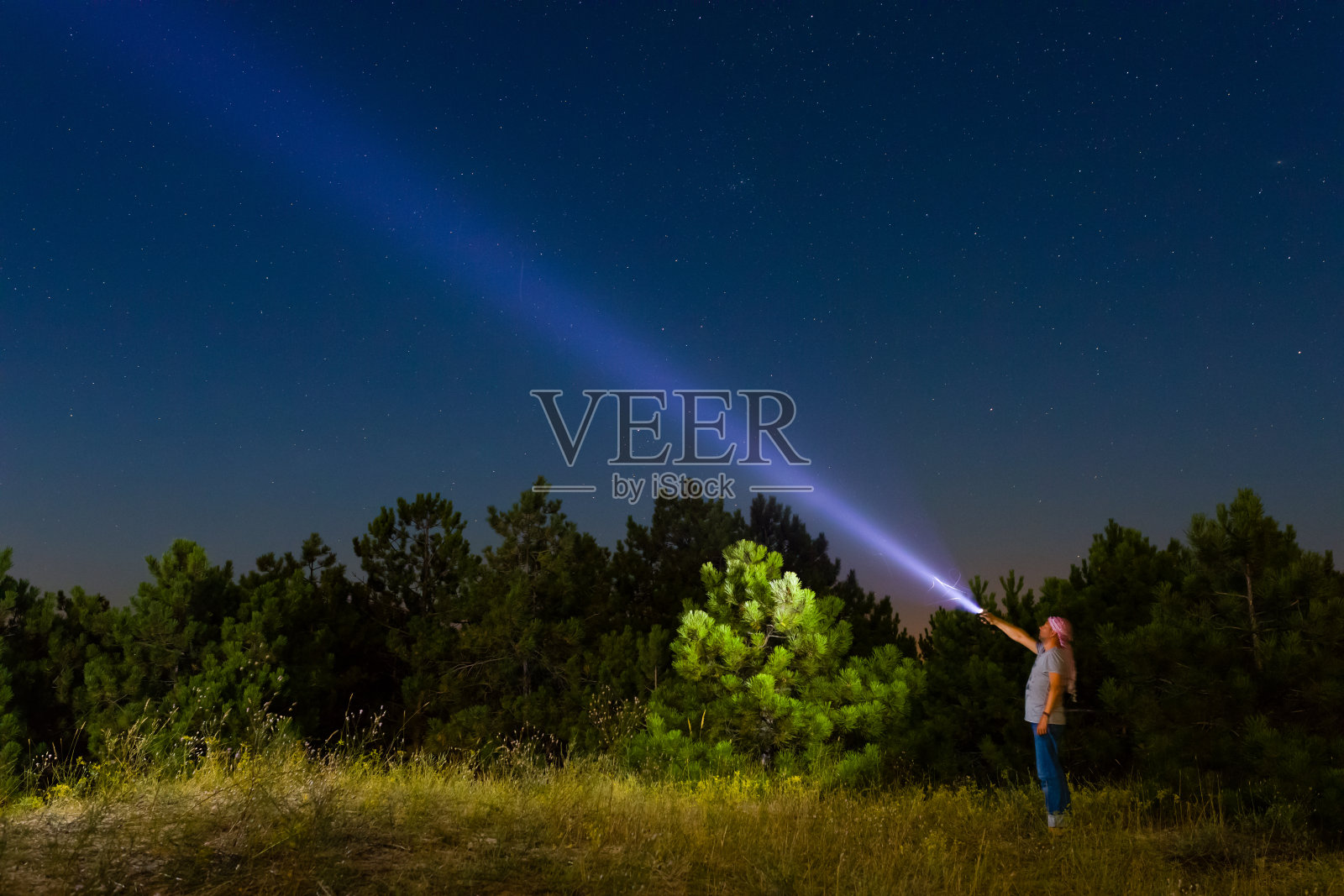 一个人用手电筒照向天空照片摄影图片