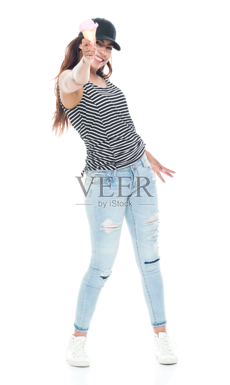 全长20-29岁美丽的拉丁美洲和西班牙裔一个年轻的女人只有/女性/年轻妇女在白色背景穿着牛仔裤/背心/帽子/帽子谁是微笑/快乐/愉快/吃/食物照片摄影图片