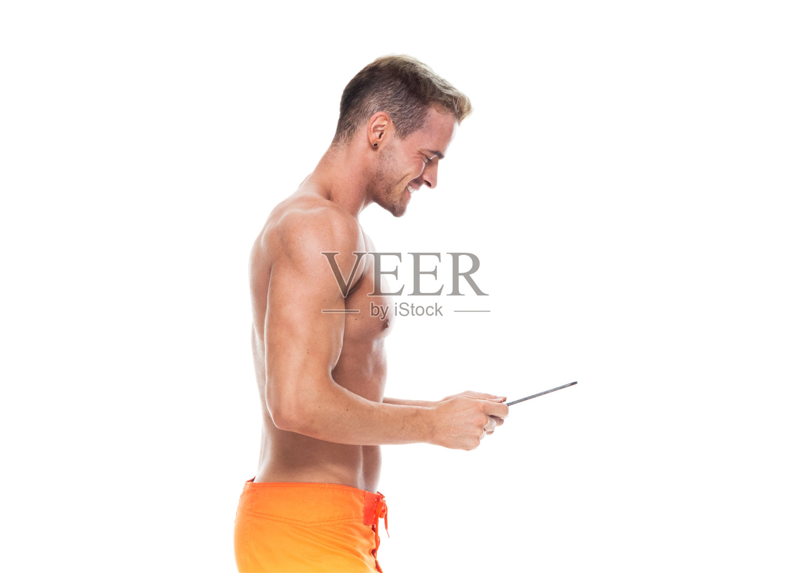 侧视图/腰部以上的20-29岁的成年英俊的人高加索青年男子/男性站在白色背景下，穿着短裤/泳衣/短裤谁是赤裸的/性感的象征/微笑/快乐/开朗照片摄影图片