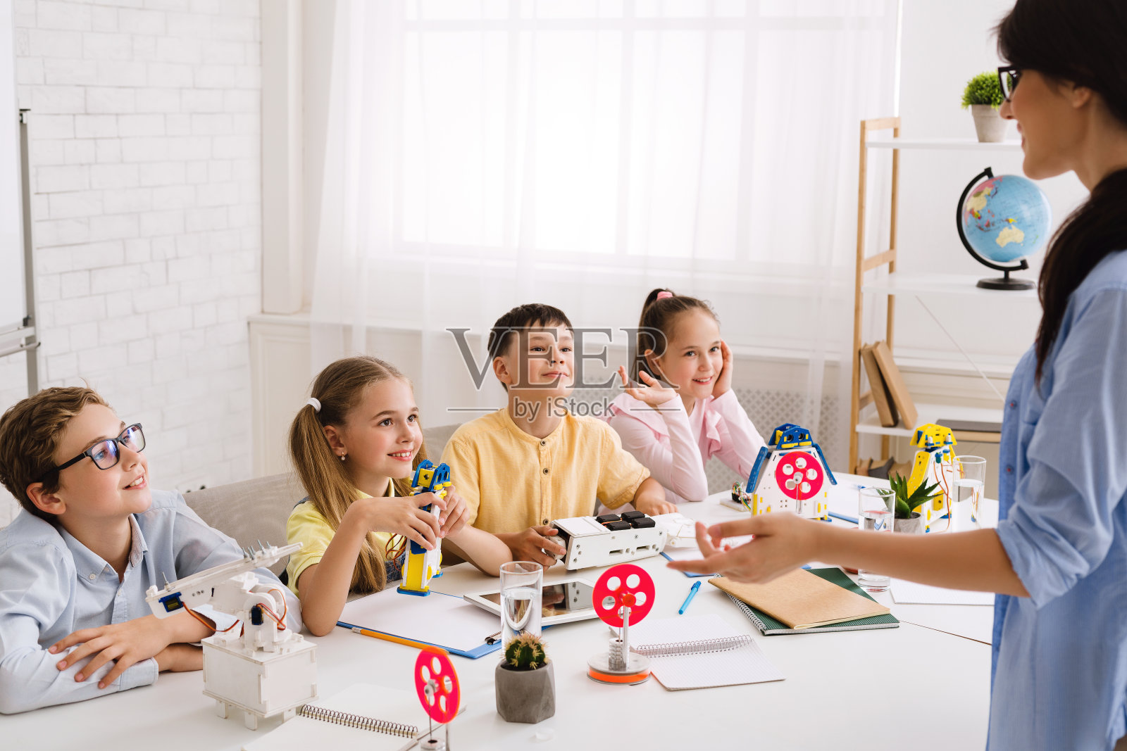 干教育。科学家向孩子们解释新材料照片摄影图片