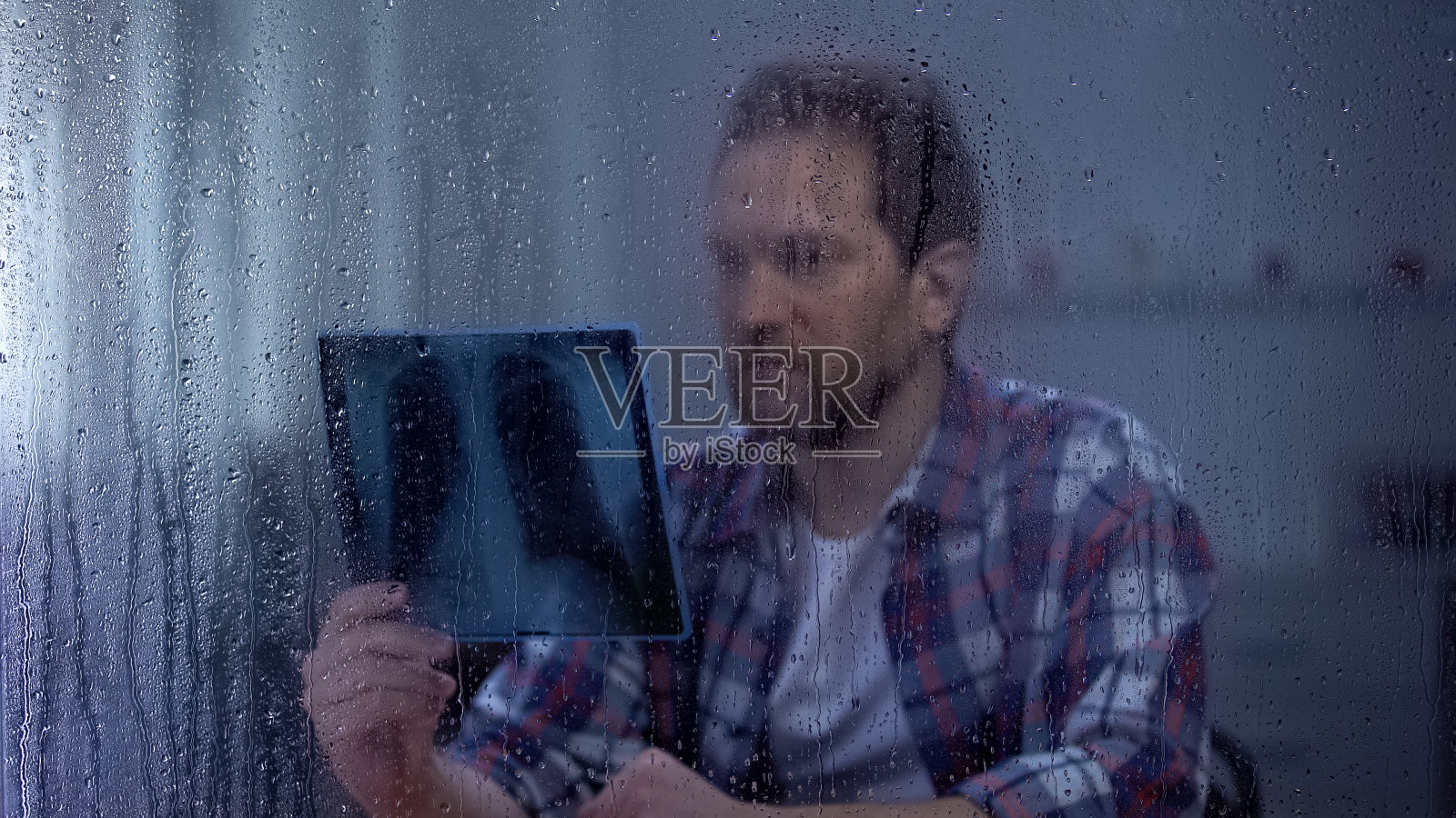 悲伤的人在看肺部x光片，致命的疾病，无望恢复，雨天照片摄影图片