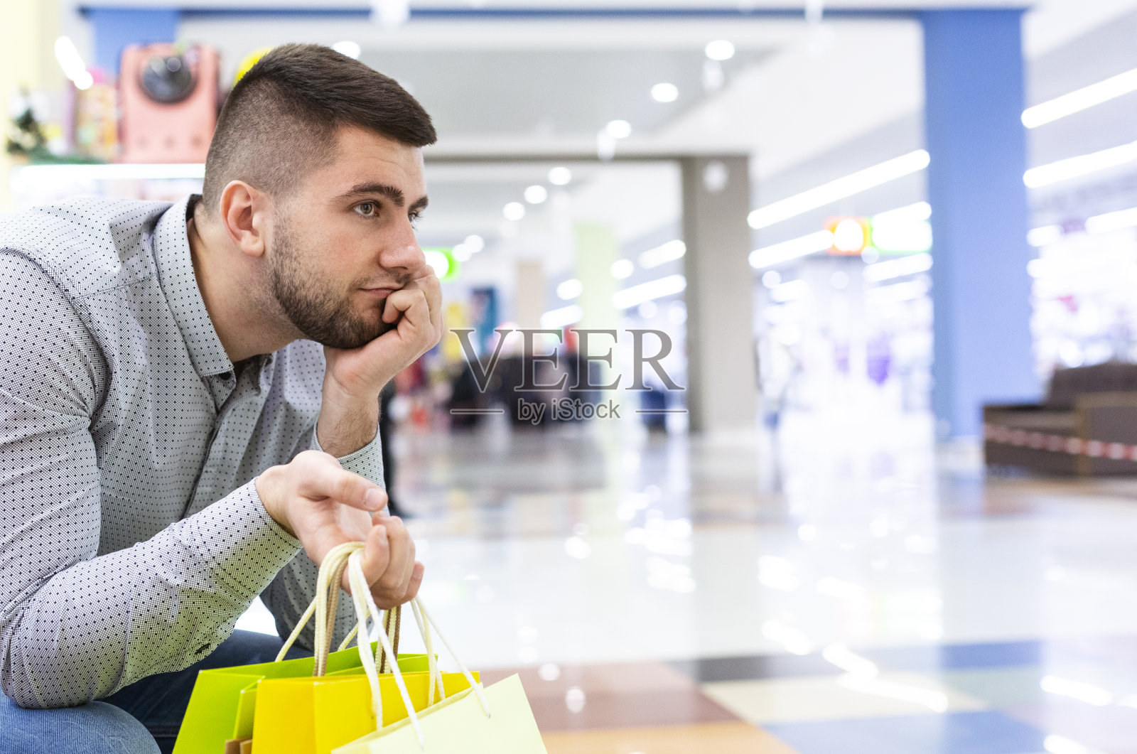 一个男人在购物中心等他的妻子照片摄影图片