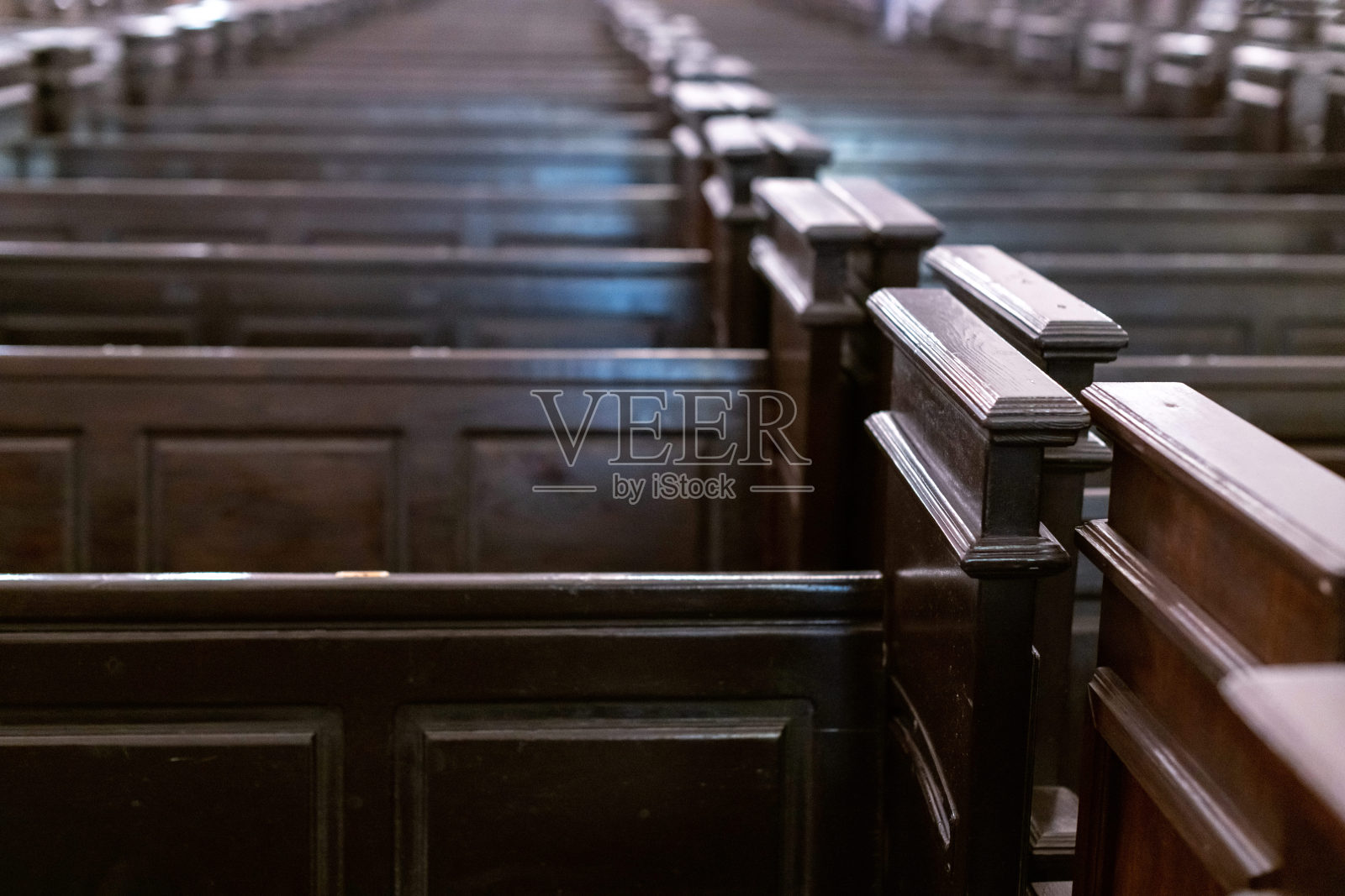 教堂长凳上。基督教教堂里一排排的长凳。沉重、坚固、不舒服的木椅。照片摄影图片