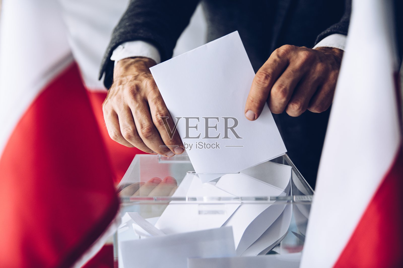 人们把他的选票放在投票箱里。照片摄影图片