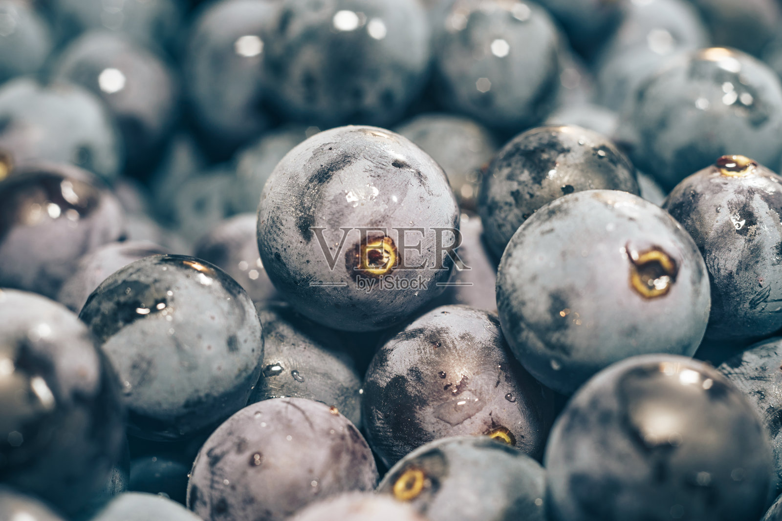 靠近新鲜的蓝色葡萄颗粒背景。宏观的观点。照片摄影图片