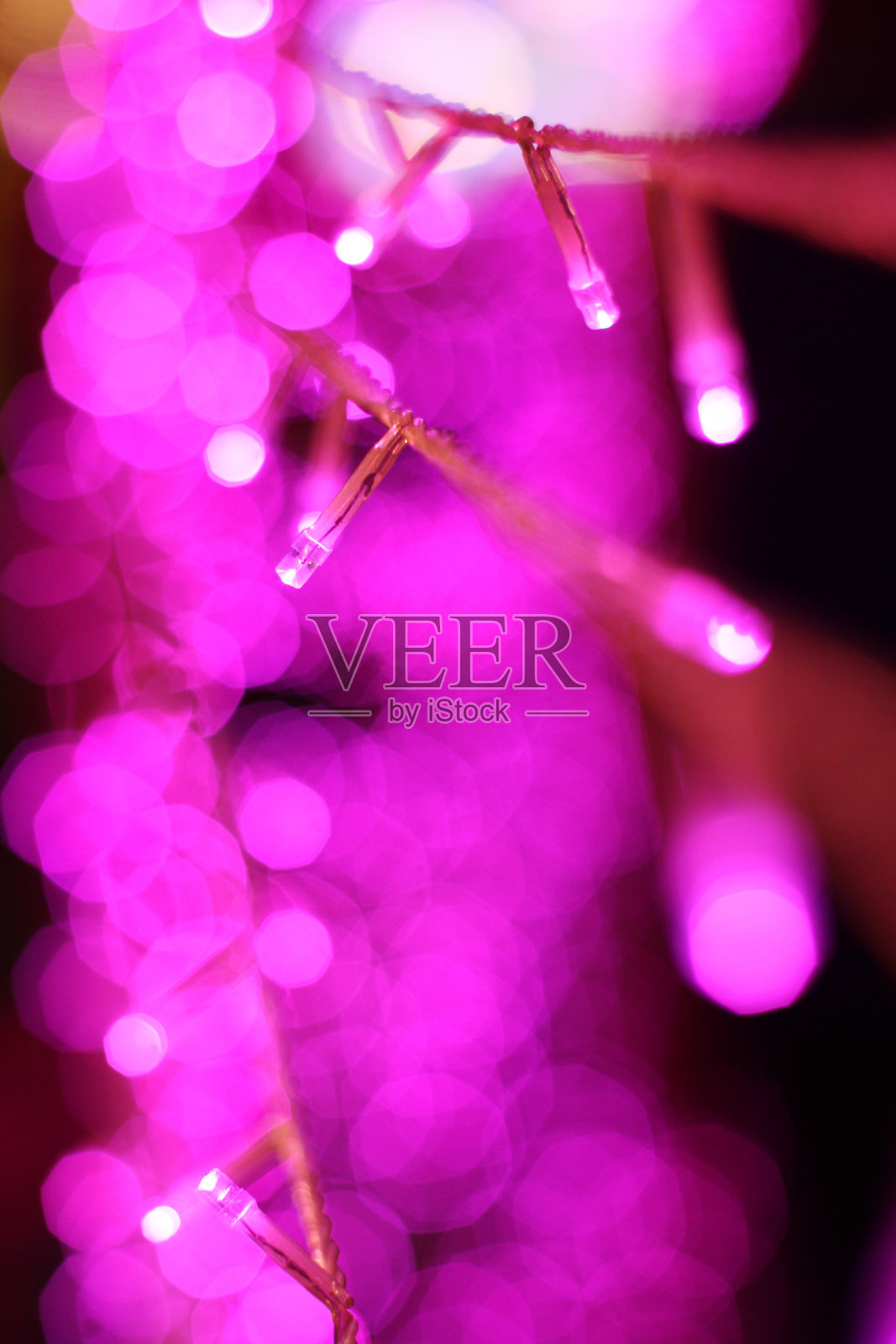 魅力金属圈的紫外光和紫色闪光散晶。五彩缤纷的圣诞节和新年发光的光抽象的圣诞节和假日的概念。照片摄影图片