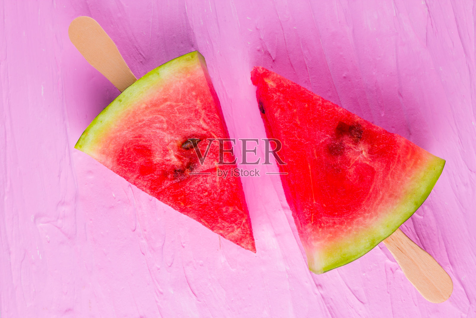 粉红背景上的西瓜冰棒。新鲜的木棒西瓜。夏天的概念照片摄影图片