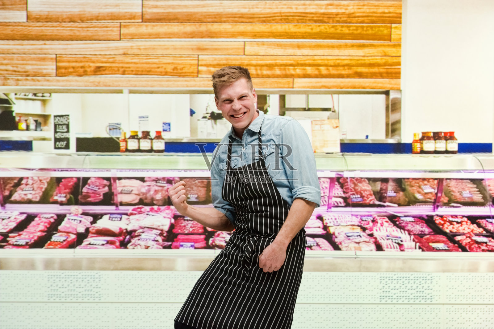 腰部以上/一个男人只有20-29岁英俊的人白人男性/年轻男性屠夫/肉店老板/熟食店/市场-零售空间/冷藏区/超市在商店穿衬衫扣照片摄影图片