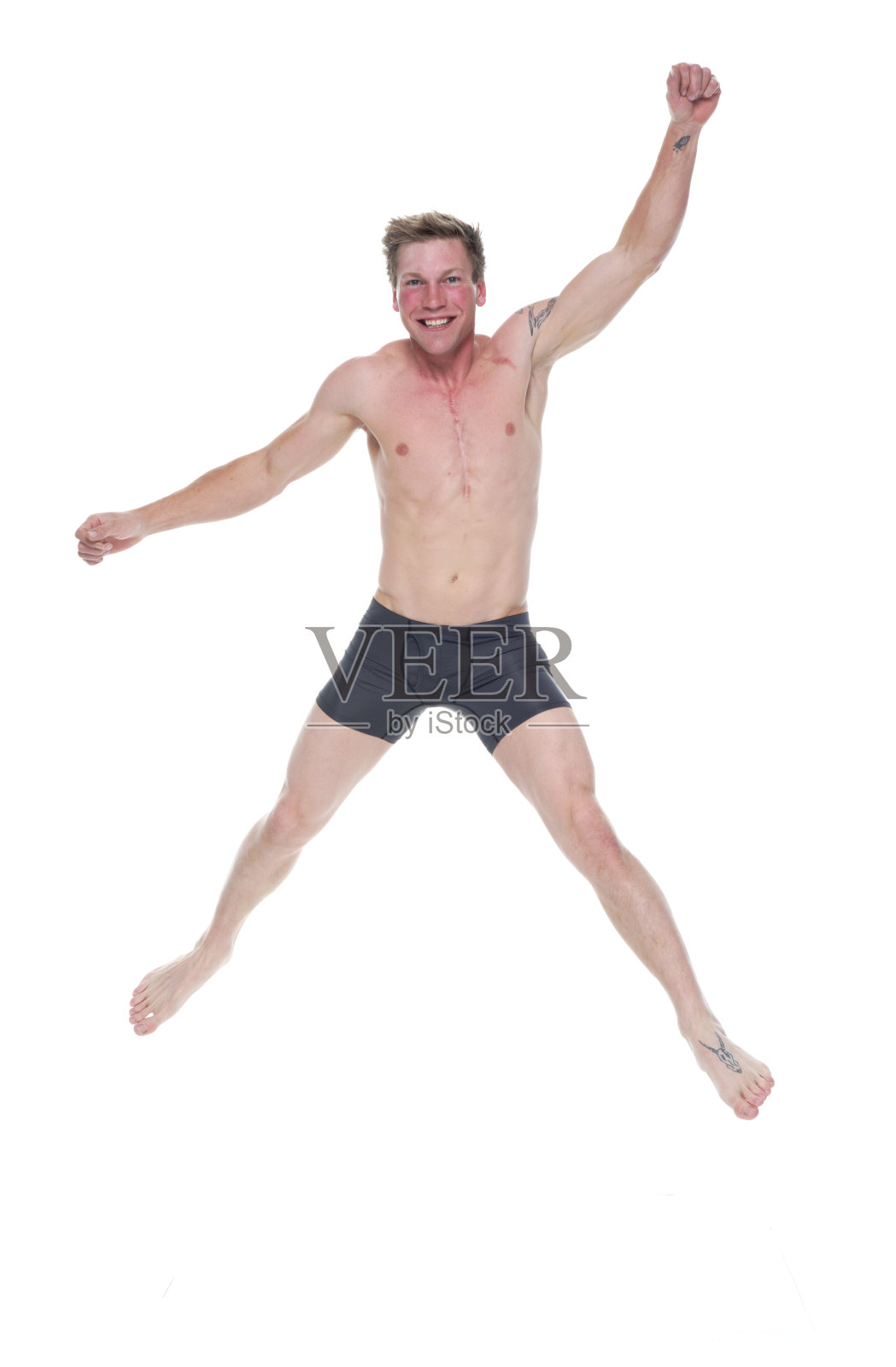 全身长度20-29岁英俊的人/短发白人男性/年轻男子跳跃在白色背景下穿着平角短裤/内裤/平角短裤/男性内裤/腹肌照片摄影图片