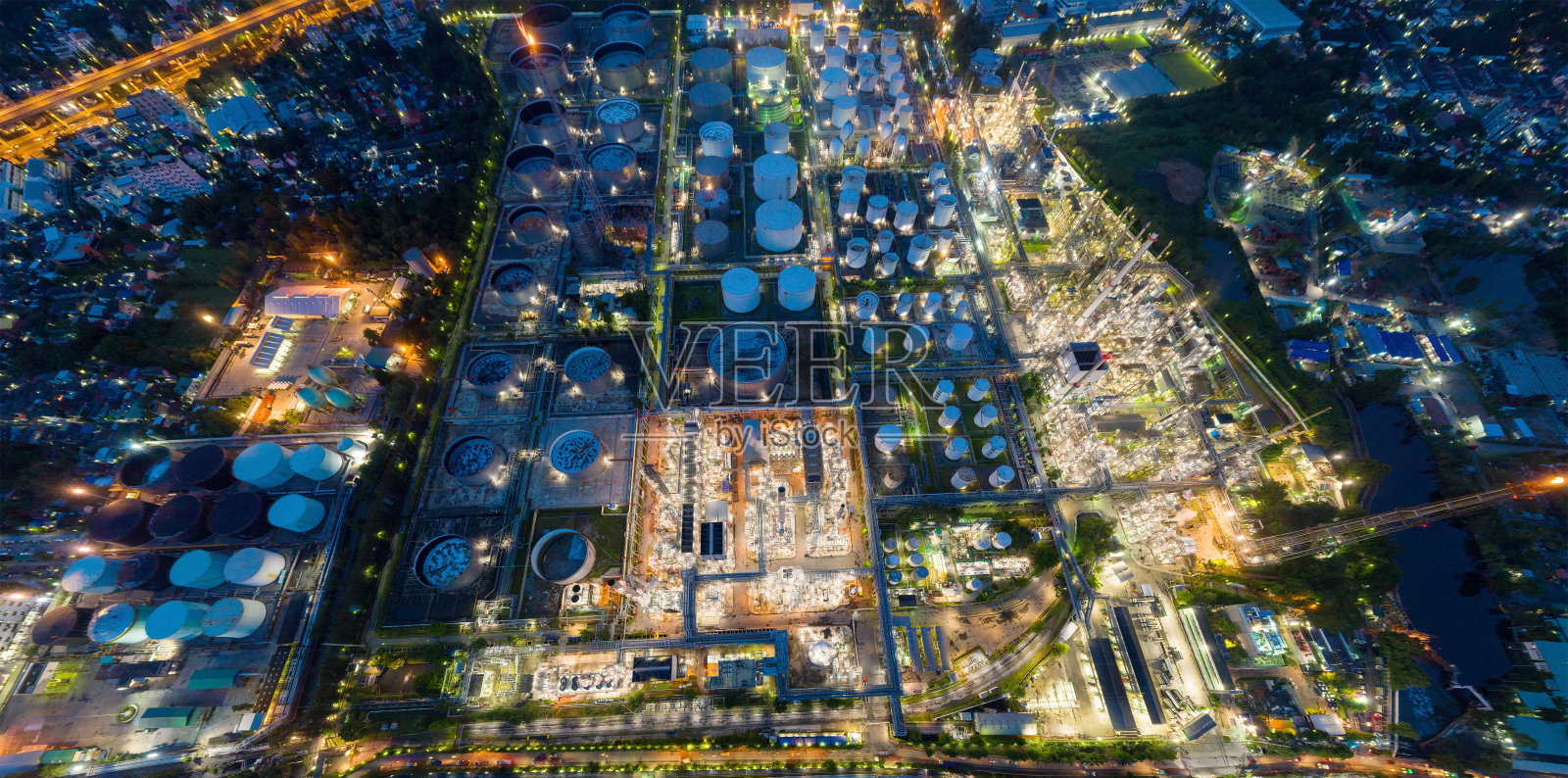 鸟瞰图石化炼油厂和海上工业工程概念在班纳区晚上，曼谷市，泰国。工业中的石油、天然气储罐管道。现代金属工厂。照片摄影图片