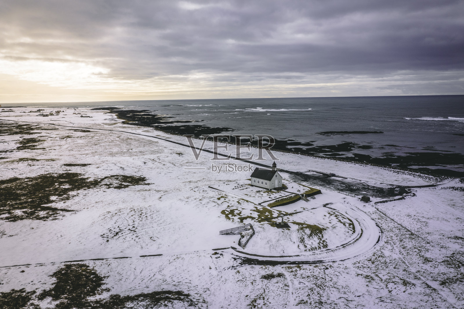 一个孤立的教堂在下雪的条件下，在海边照片摄影图片