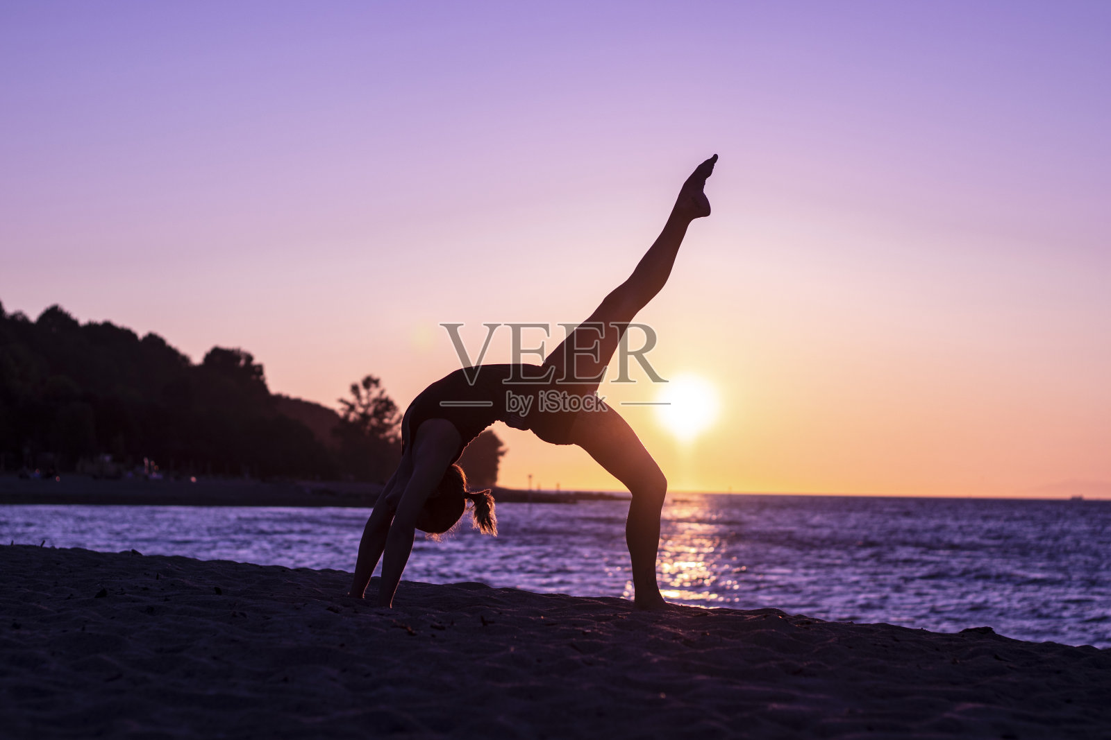 女人瑜伽放松在海滩上日落照片摄影图片