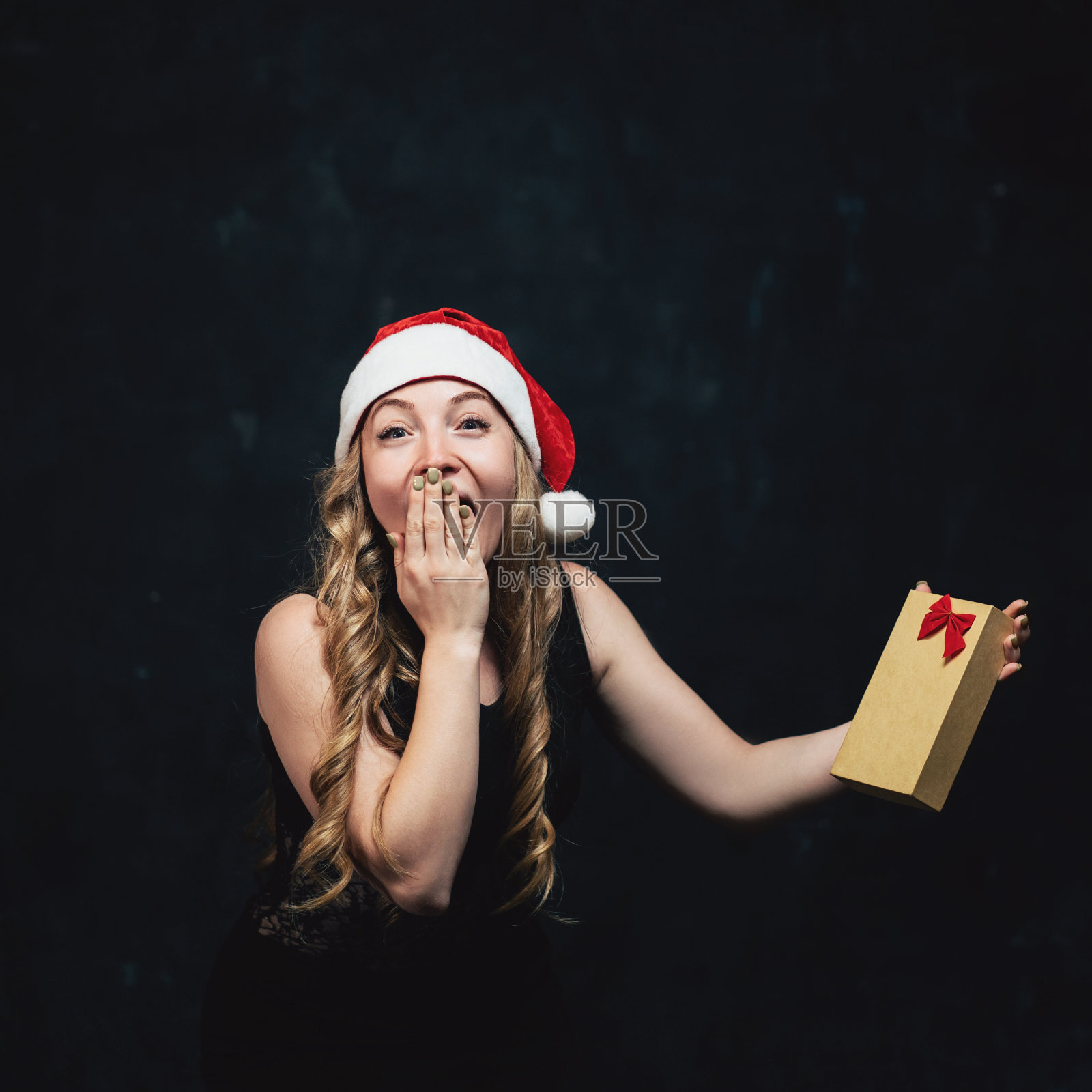 带着礼物盒和圣诞老人帽的快乐女人照片摄影图片