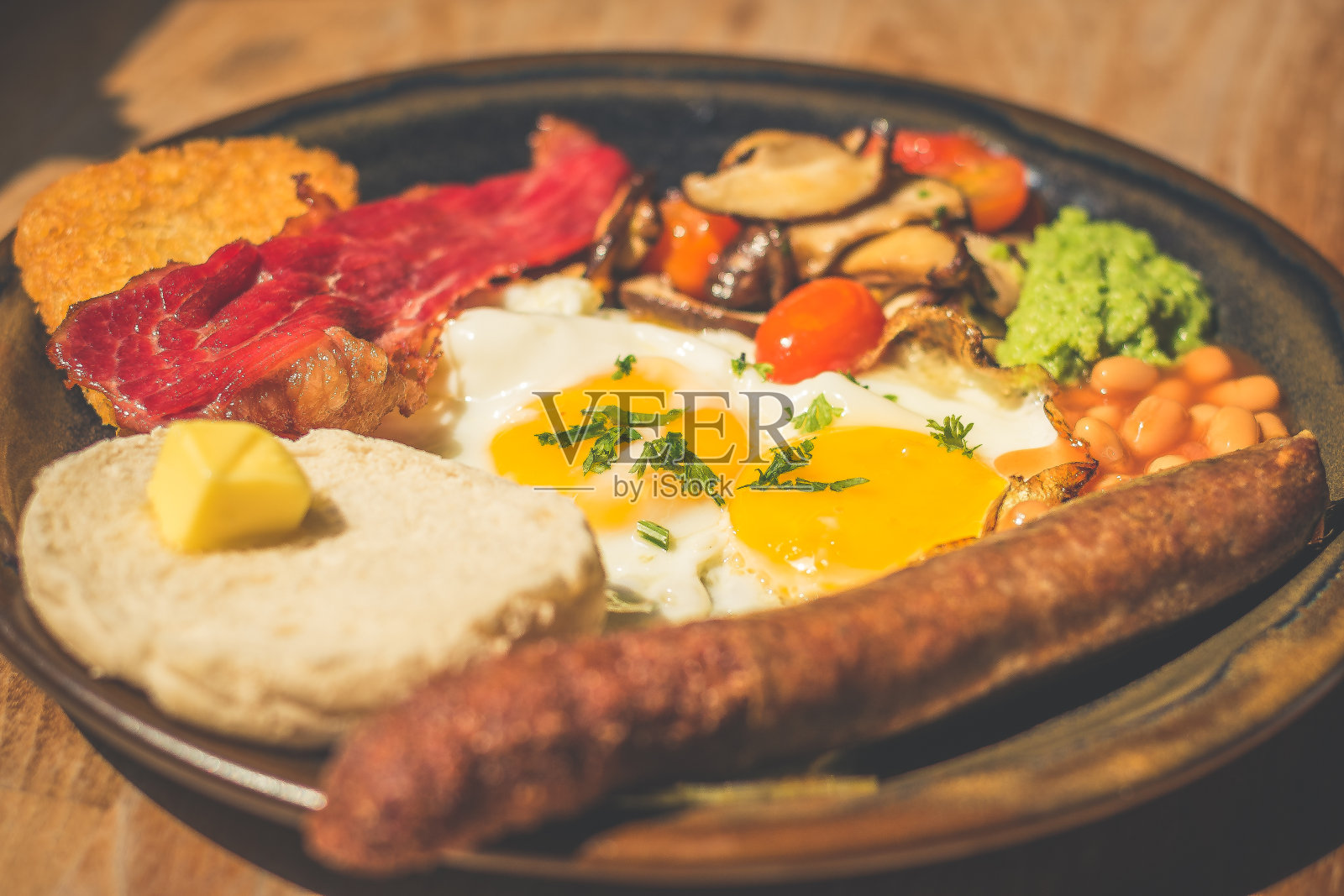 大蒜和香草牛肉香肠配烤豆，牛肉培根，樱桃番茄，鸡蛋，土豆泥，豌豆糊，蘑菇和吐司照片摄影图片