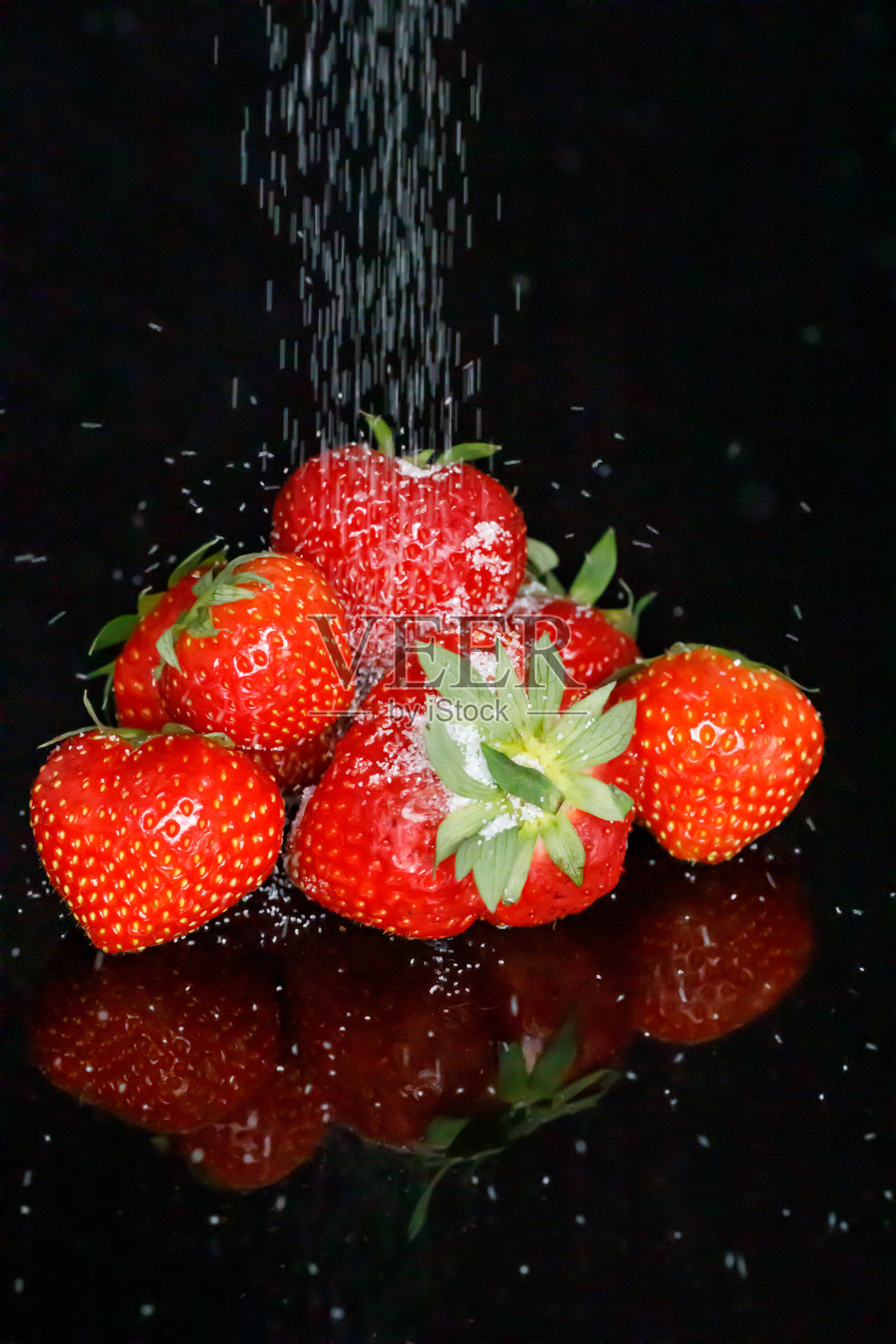 把糖倒在新鲜的红草莓上照片摄影图片