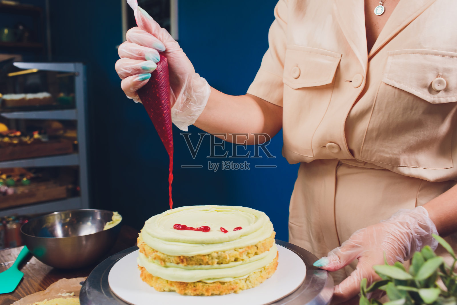 女人的手用烹饪抹刀用白奶油制作饼干蛋糕。照片摄影图片