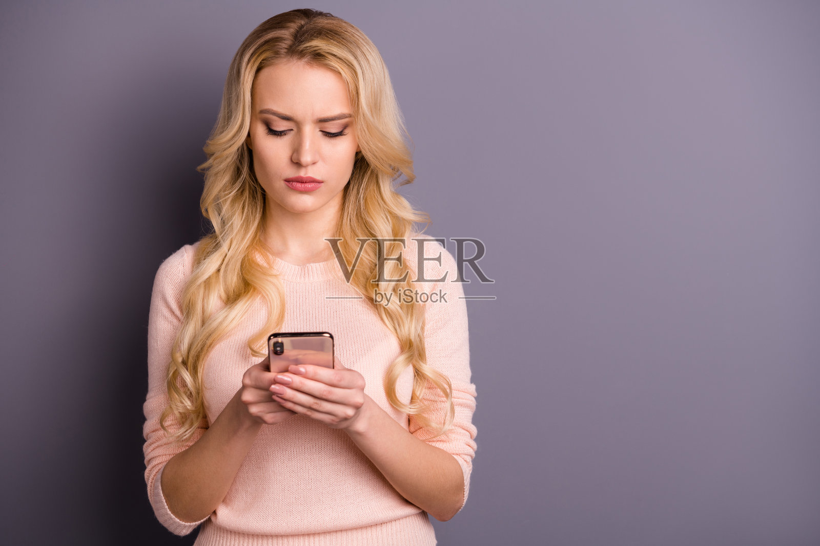 照片严肃的女士抱着电话在怀里读政治文章穿休闲套头衫孤立的灰色背景照片摄影图片