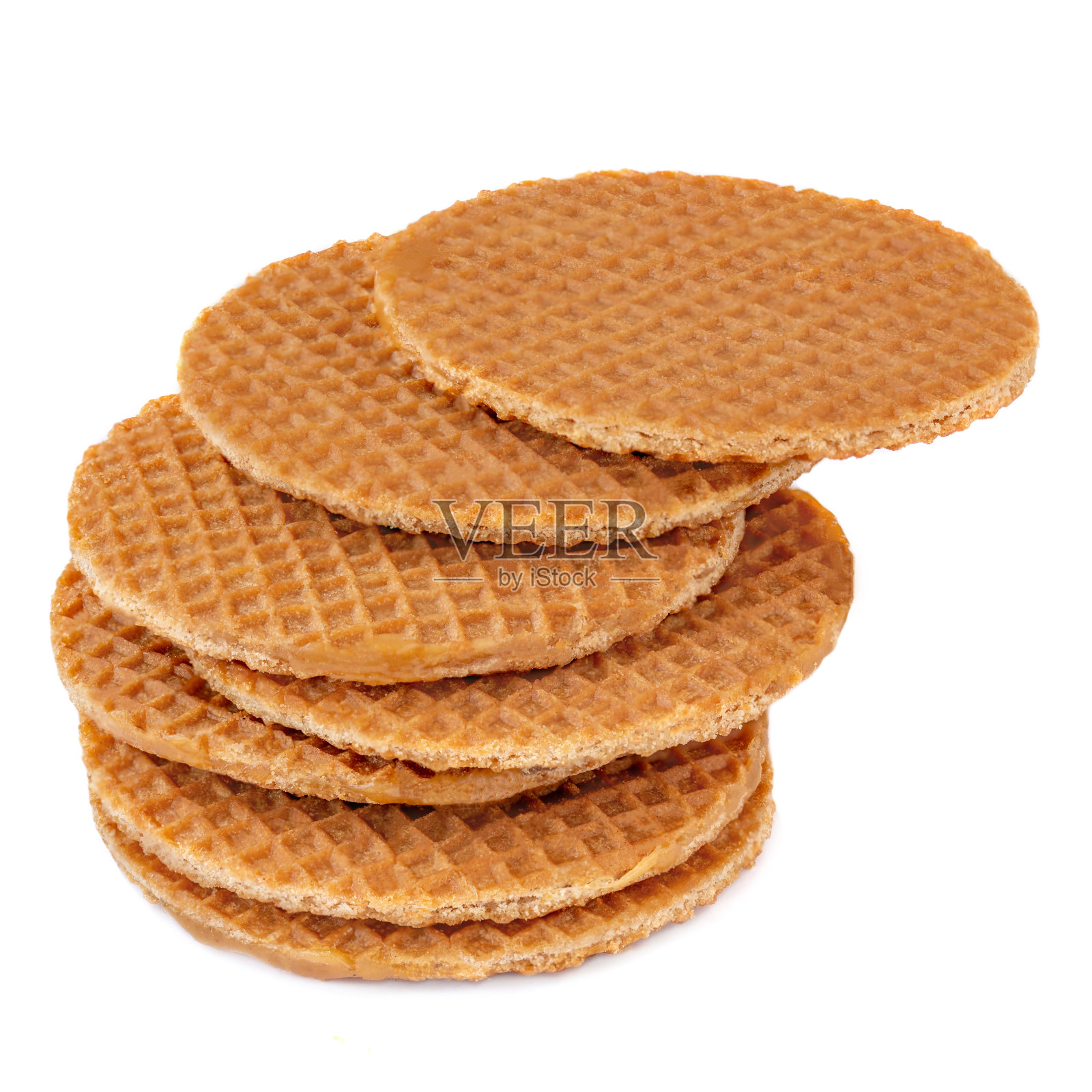 一堆荷兰圆华夫饼，白底上有焦糖和蜂蜜。焦糖松饼侧视图。关闭了。照片摄影图片