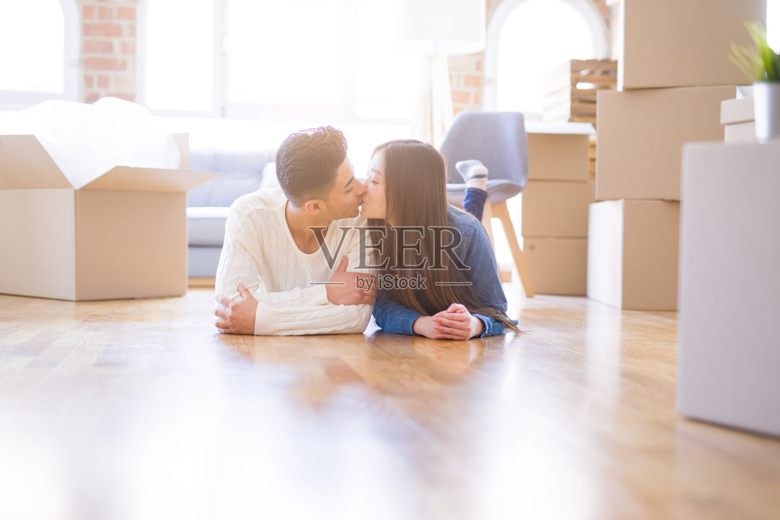 年轻的亚洲夫妇躺在地板上的新房子周围的纸箱放松和快乐的微笑照片摄影图片