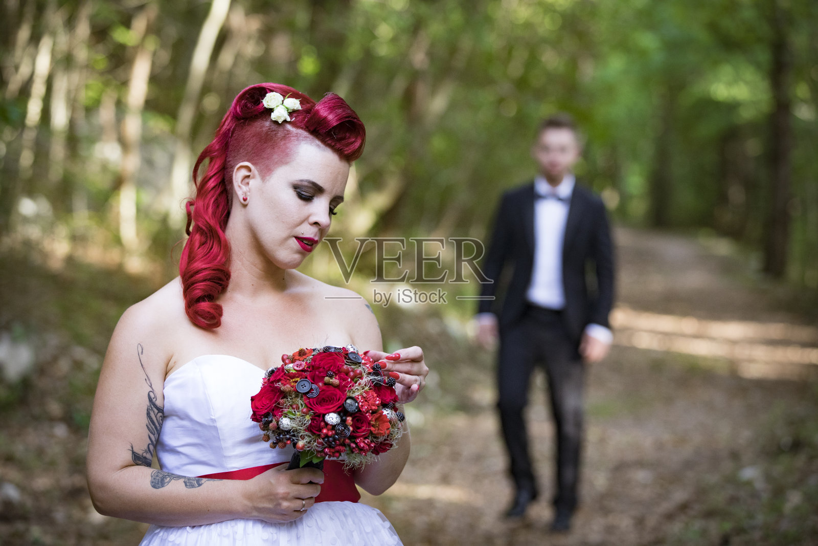 新娘看着她的花束，等待丈夫照片摄影图片