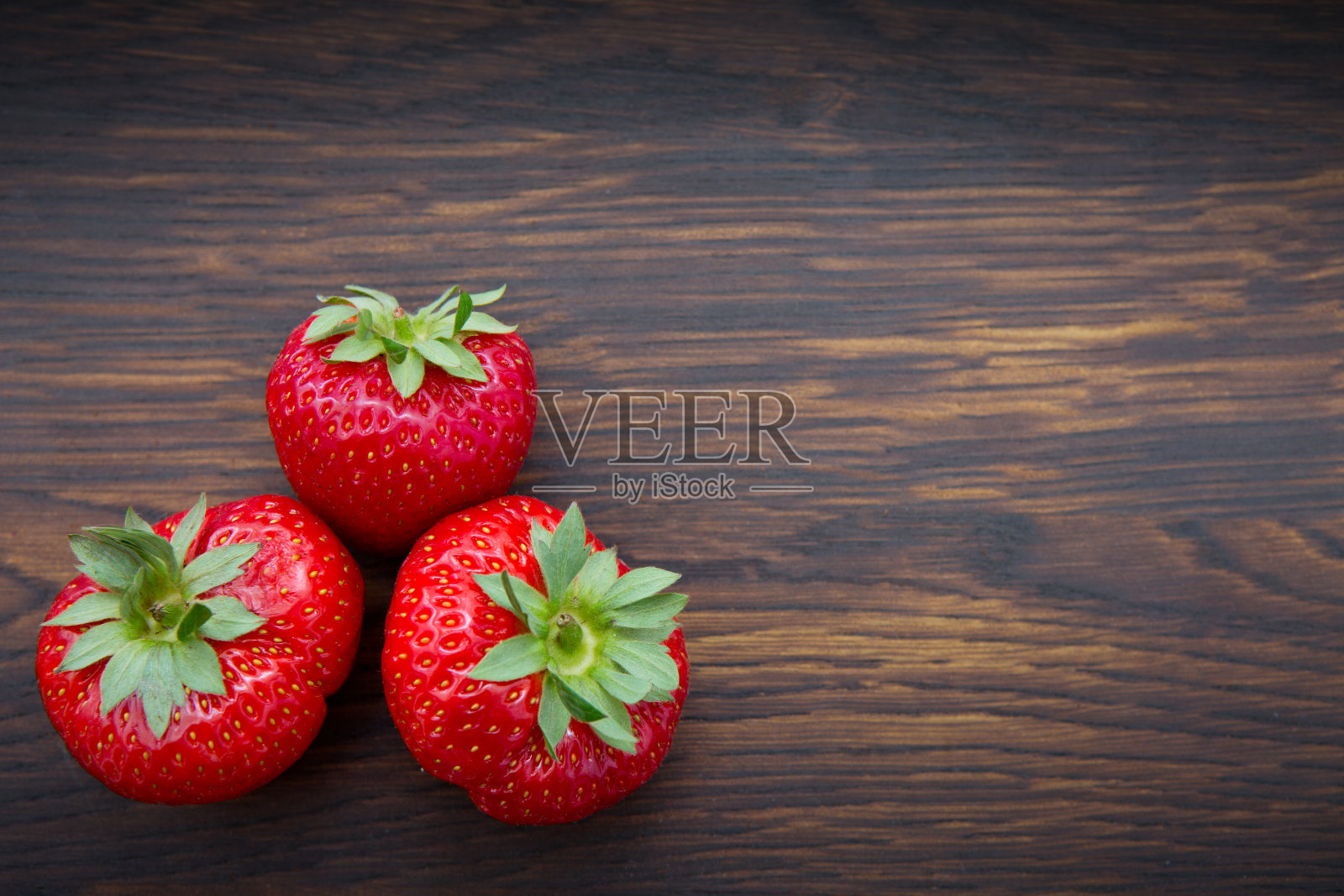 微距拍摄草莓在木制背景。照片摄影图片