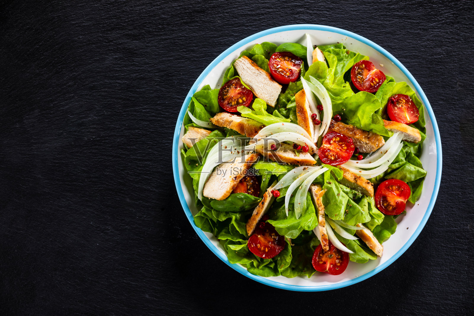 凯撒沙拉-蔬菜沙拉配烤鸡肉黑石照片摄影图片