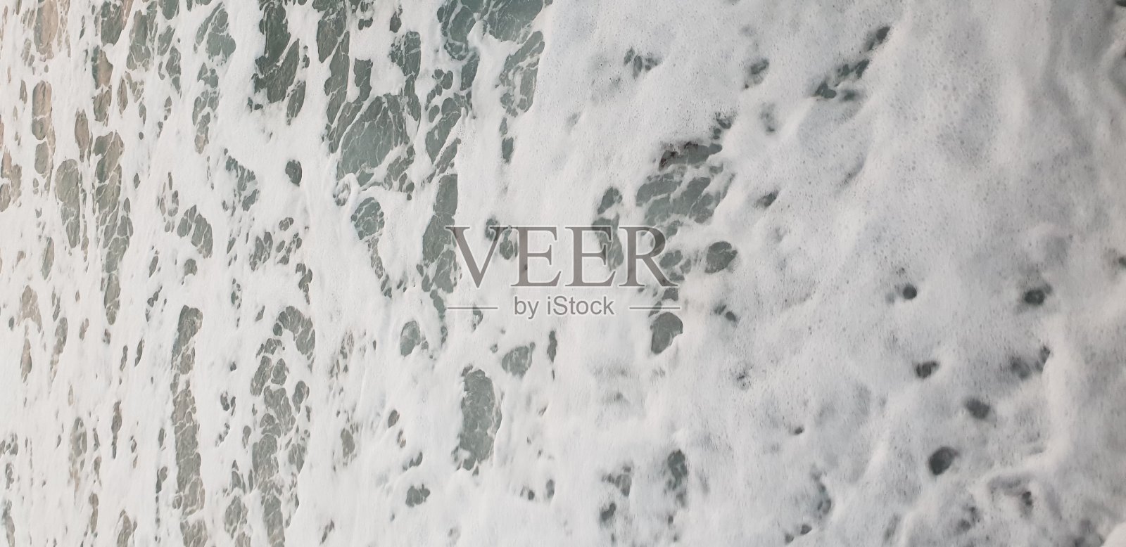 以大海为背景的碎石和海面上的泡沫照片摄影图片