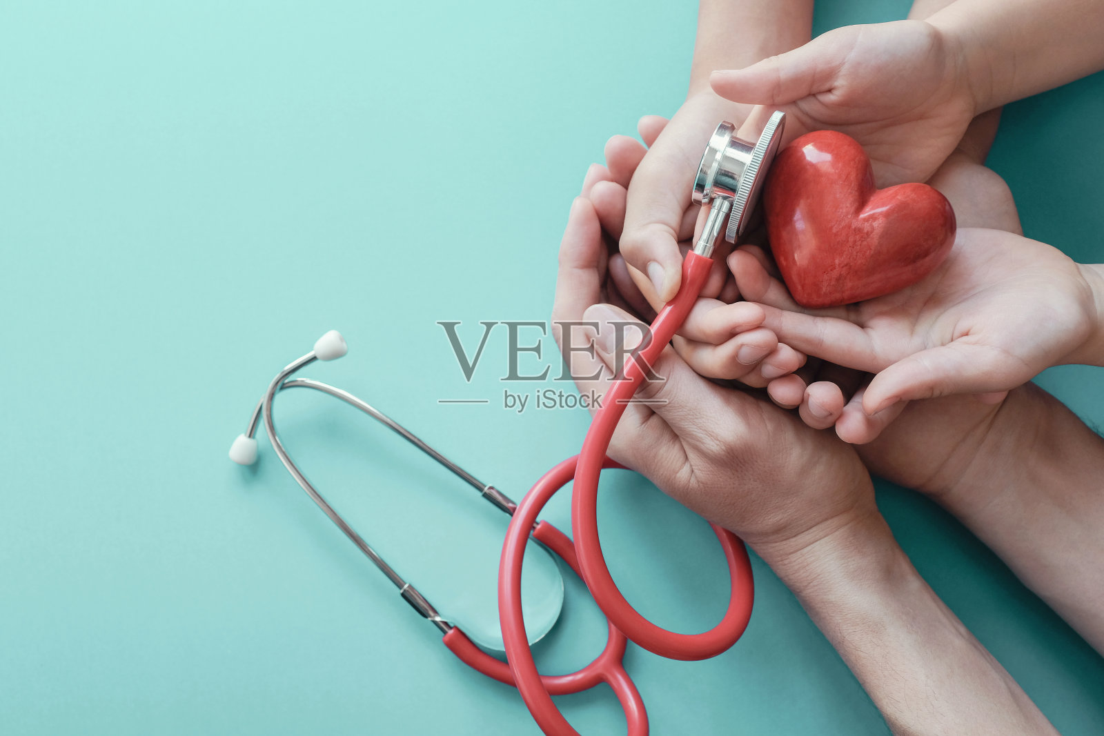 家人手捧红心用听诊器、心脏健康、健康保险概念、世界心脏日、世界卫生日照片摄影图片