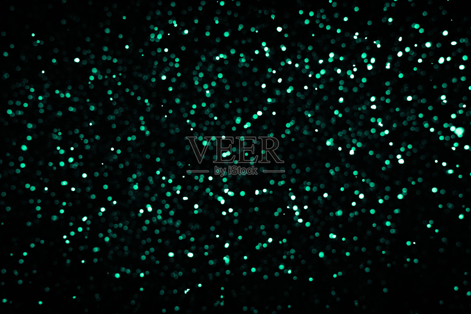 散焦的绿色灯光和闪烁在黑色的背景上照片摄影图片