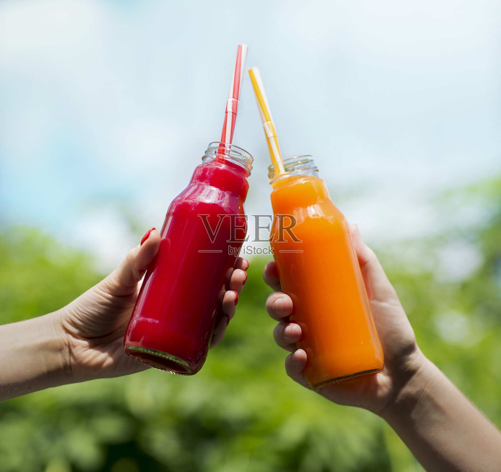 明亮的颜色排毒清爽果汁在女孩的手中照片摄影图片