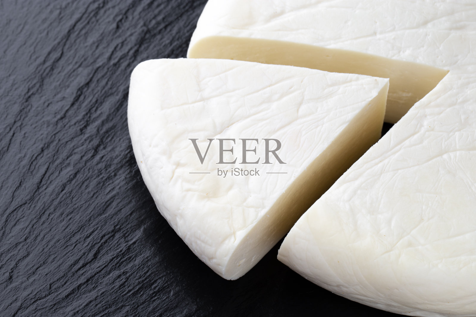 石板表面上的奶酪。一块奶酪特写。照片摄影图片