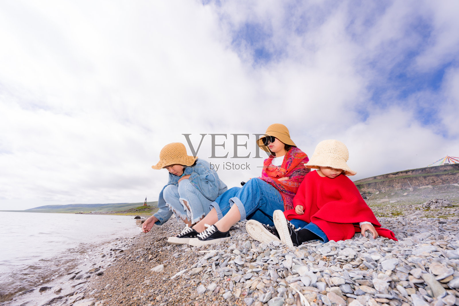 母亲和两个女儿在湖边照片摄影图片