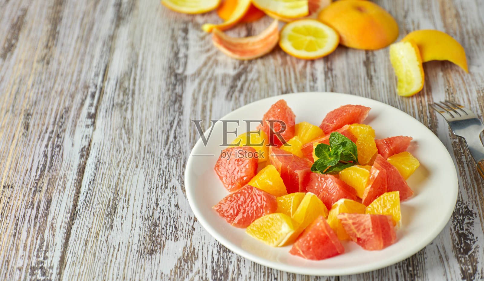 破旧的木桌上放着橙子-葡萄柚柑橘沙拉。副本的空间。夏天维生素沙拉。照片摄影图片